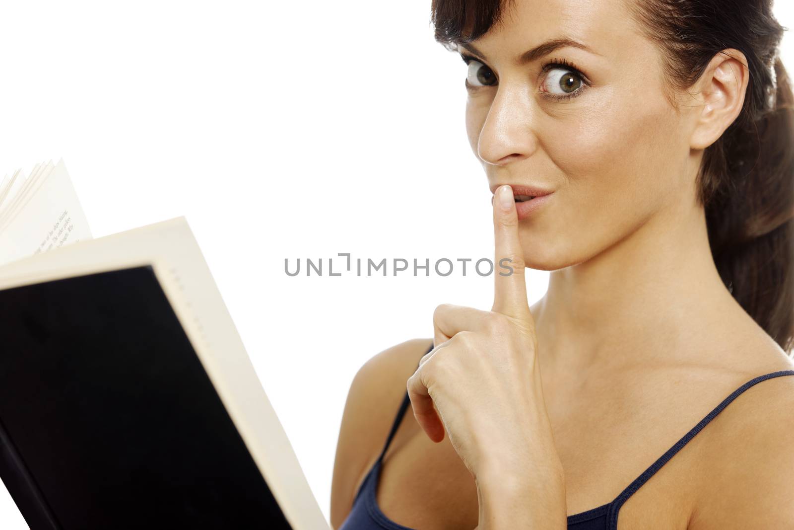 Young woman reading a book holding her finger over her mouth for quiet