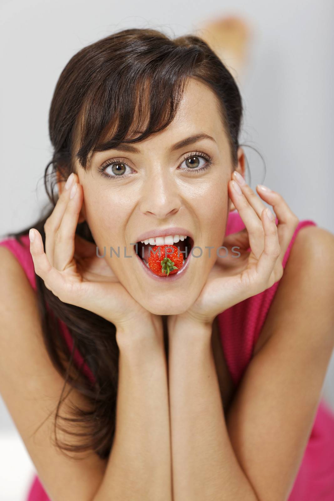 Young woman eating fresh strawberries