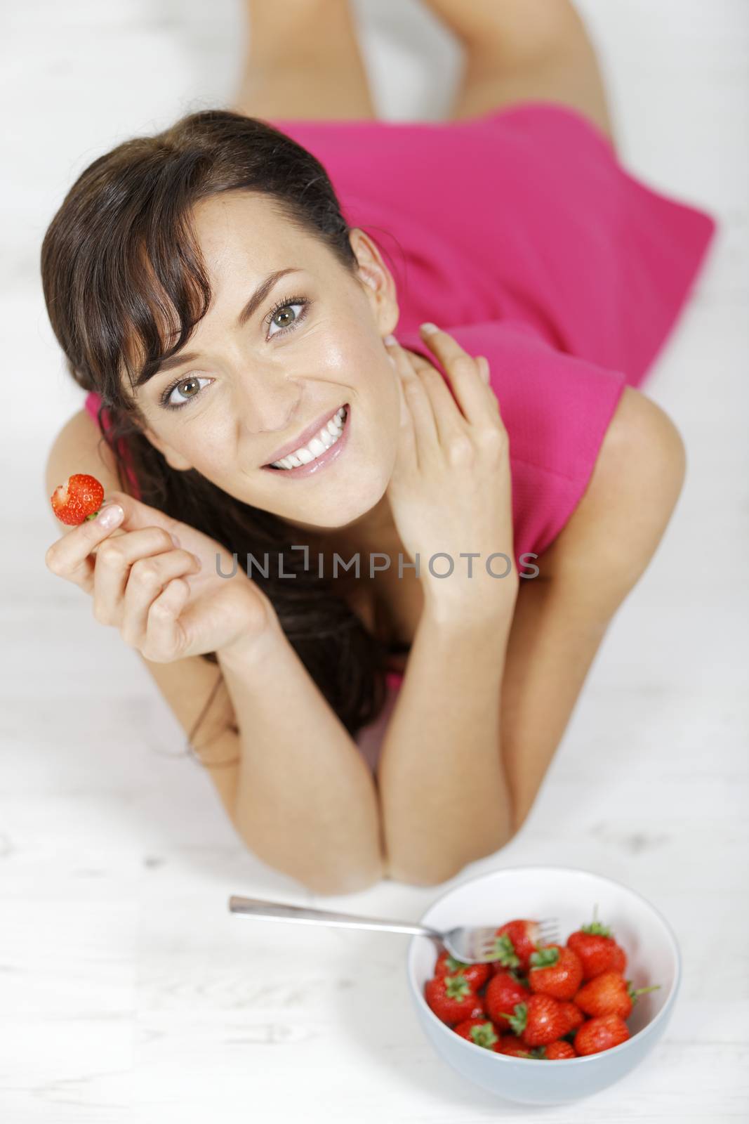 Woman eating strawberries by studiofi