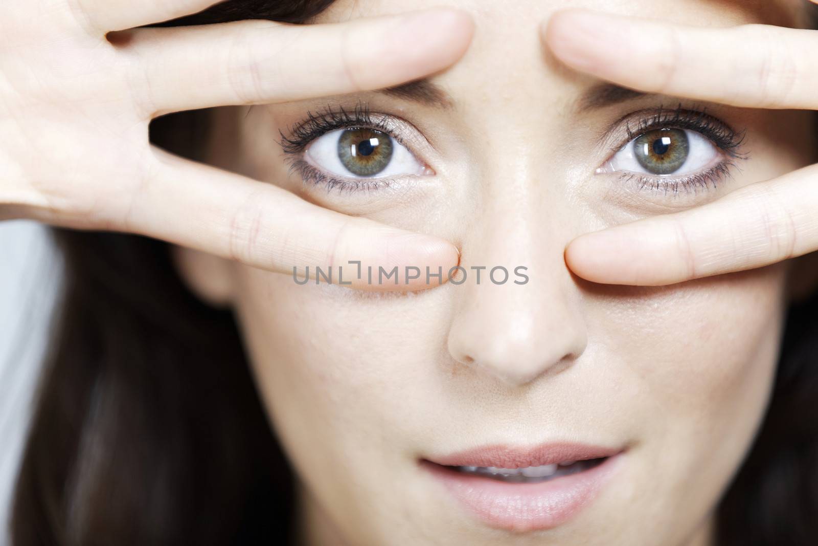 Young woman dancing and covering eyes with fingers