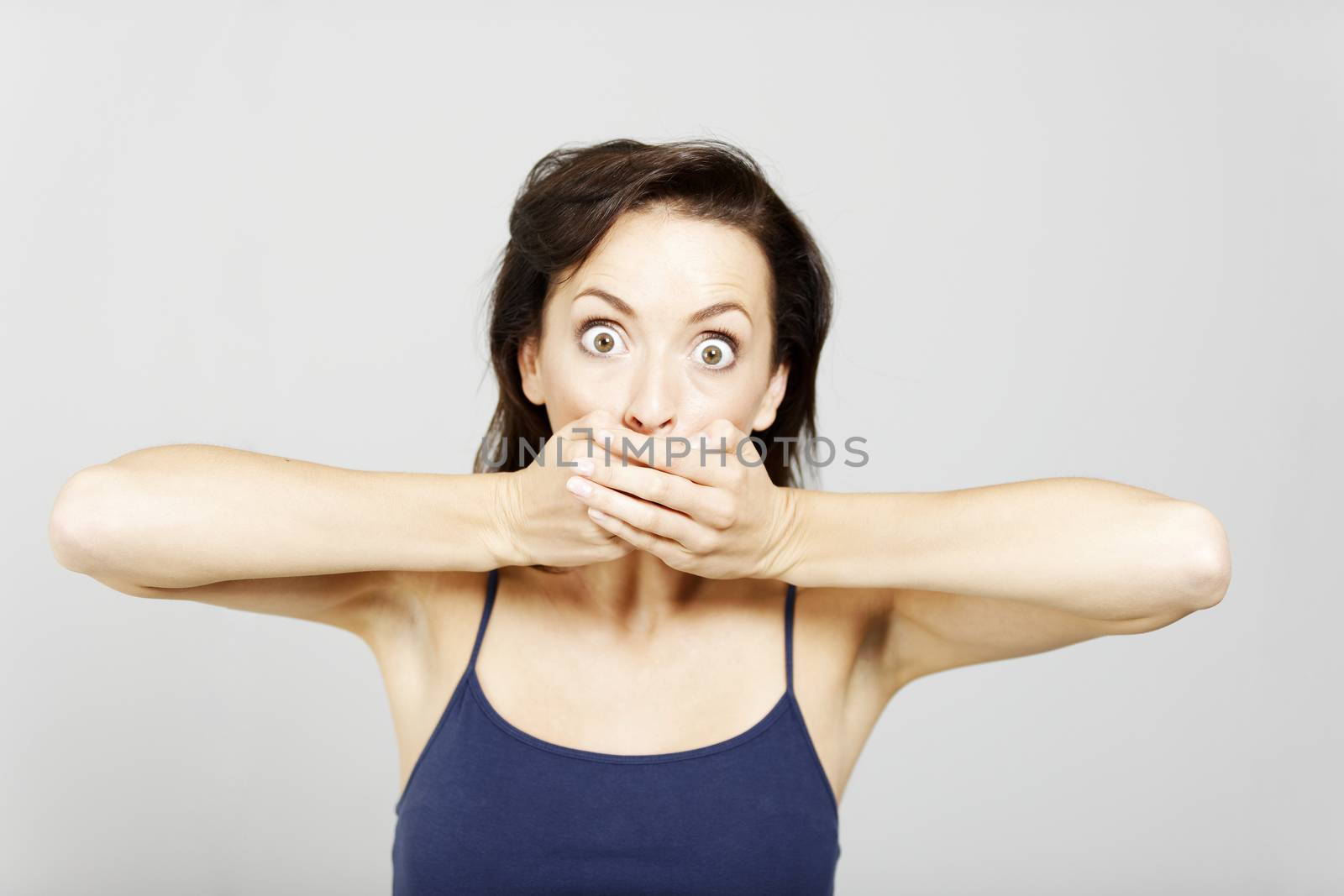 Young woman covering mouth with hands expressing shock