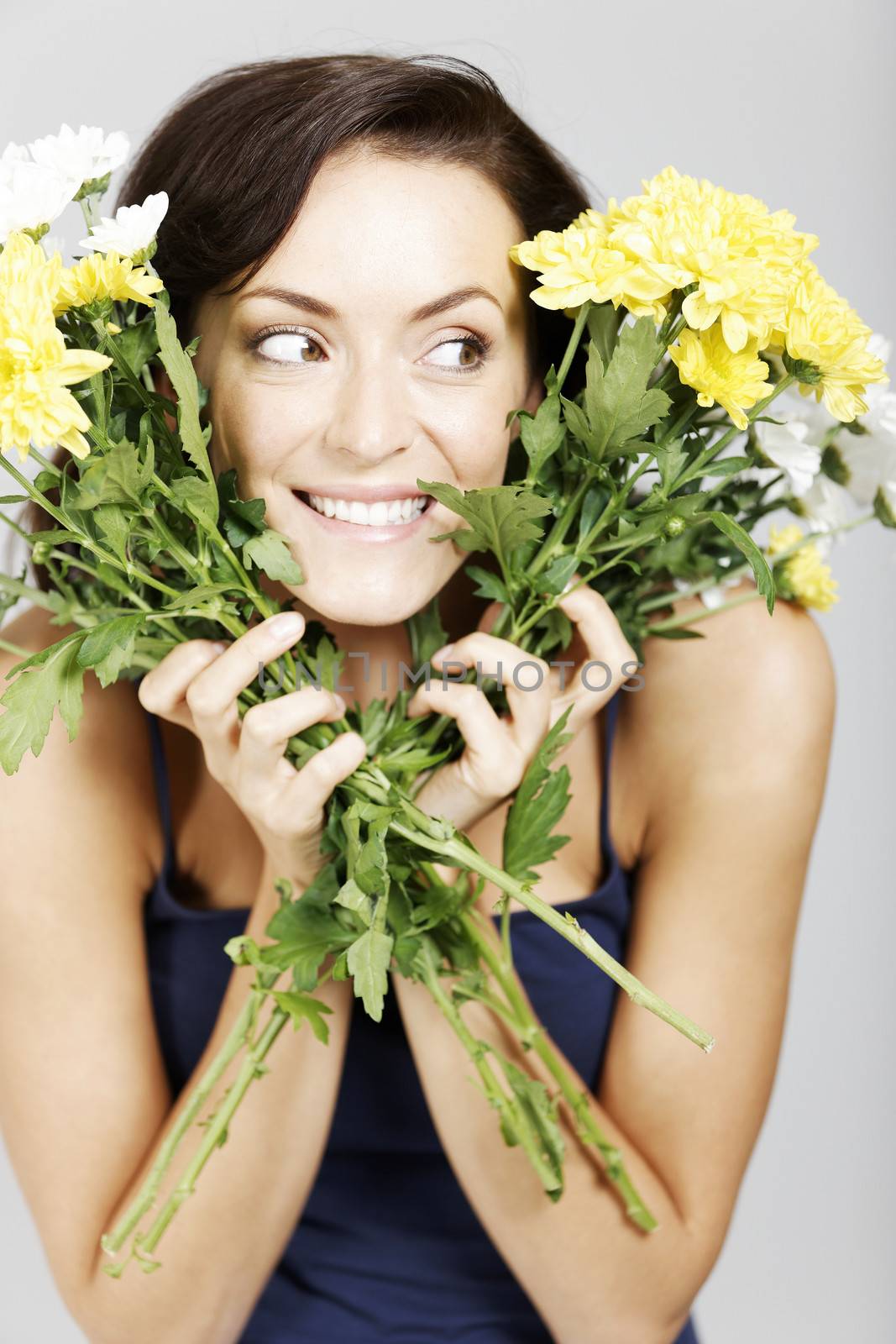 Young woman looking through two bunches of flowers