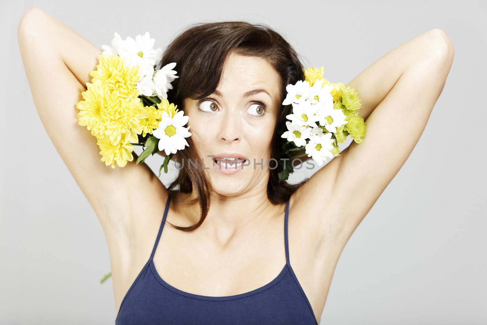 Woman holding flowers next to her head.