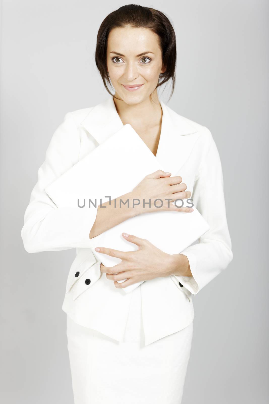 Business woman in white suit holding a laptop