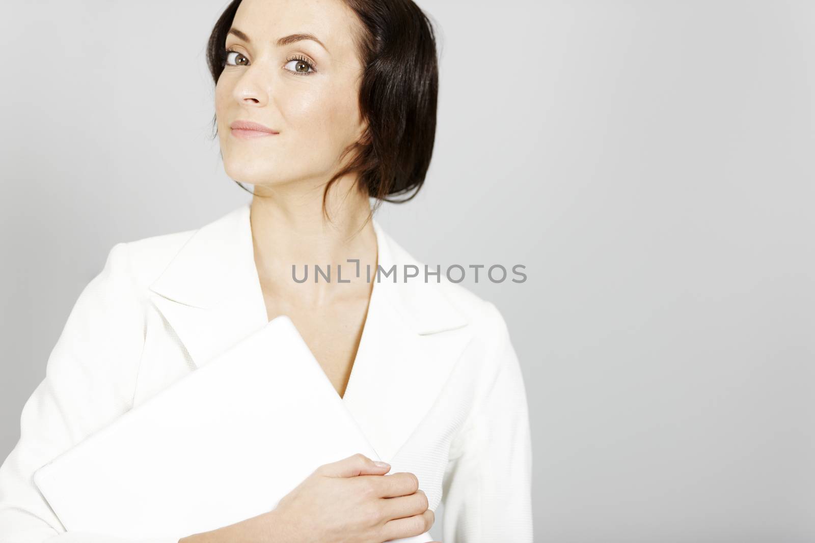 Business woman in white suit holding a laptop