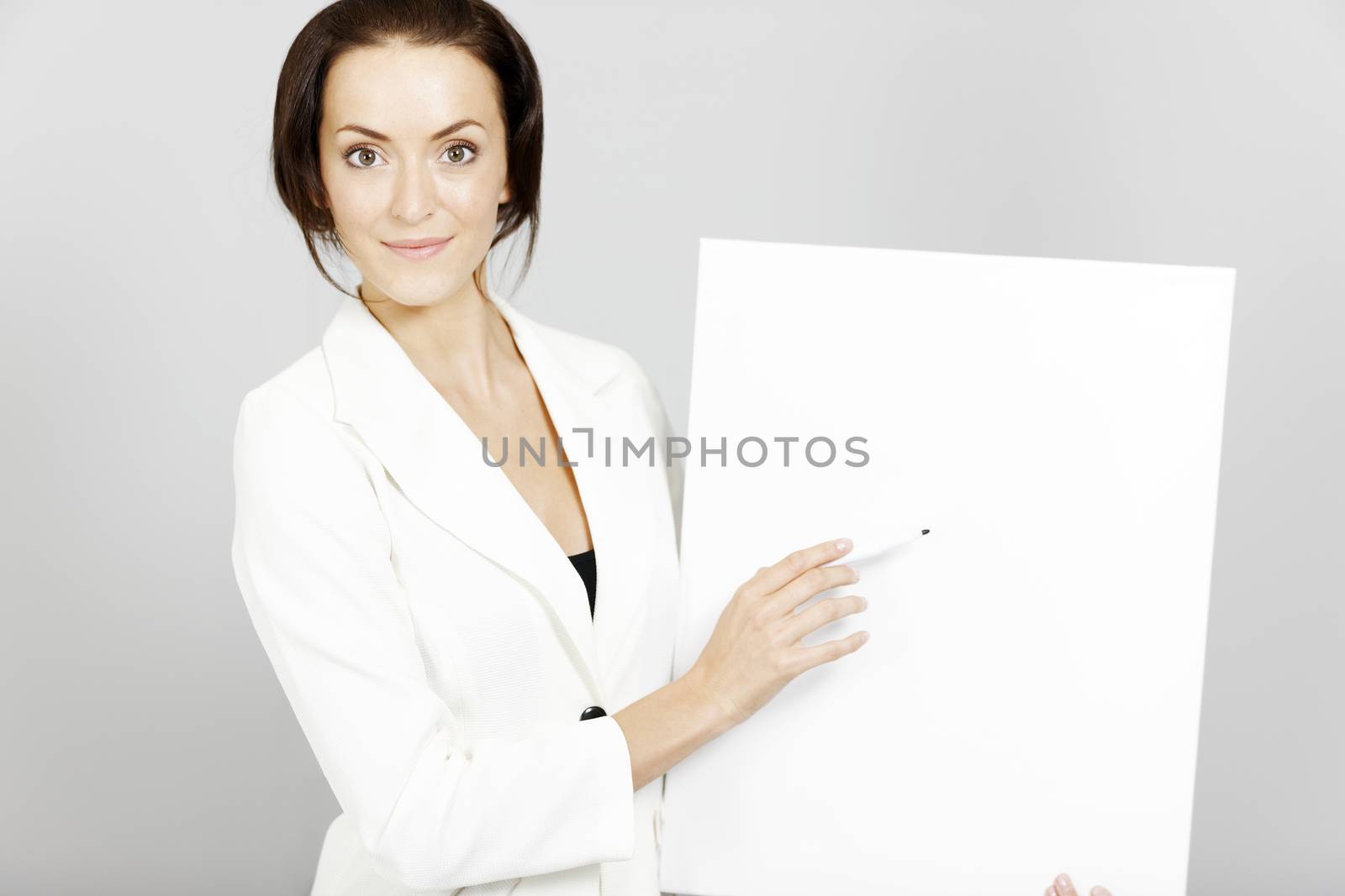 Business woman holding a wipe board during a presentation.