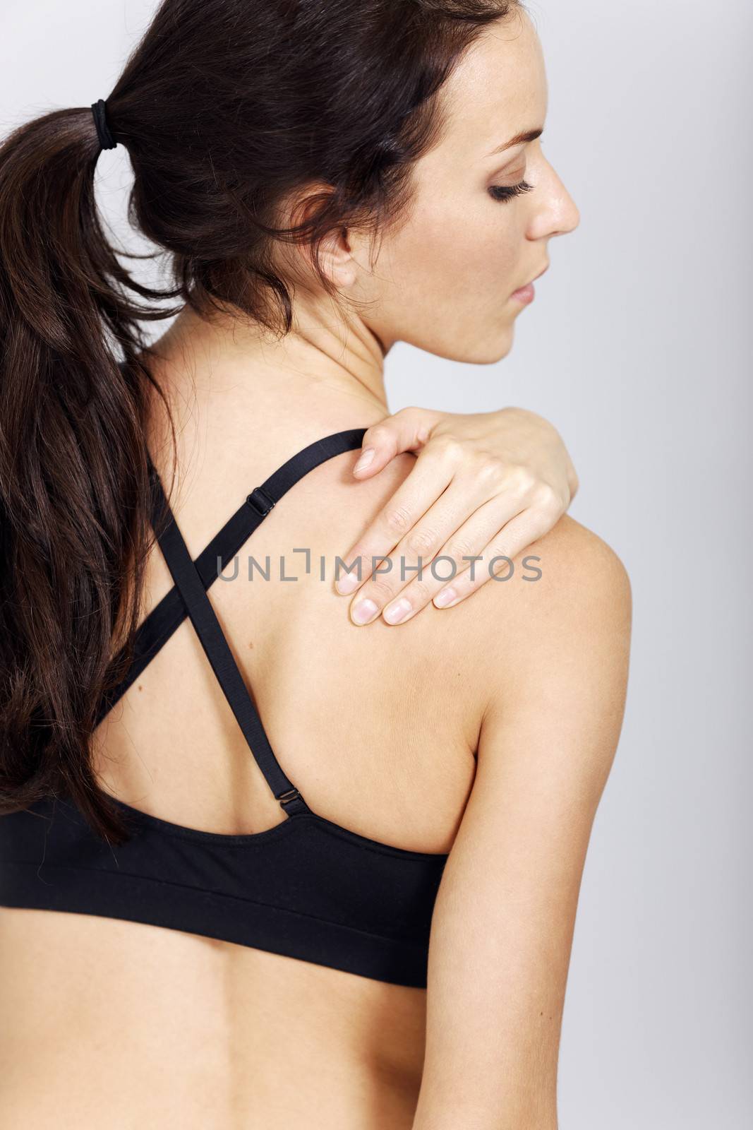 Young woman with muscle pain after fitness workout.