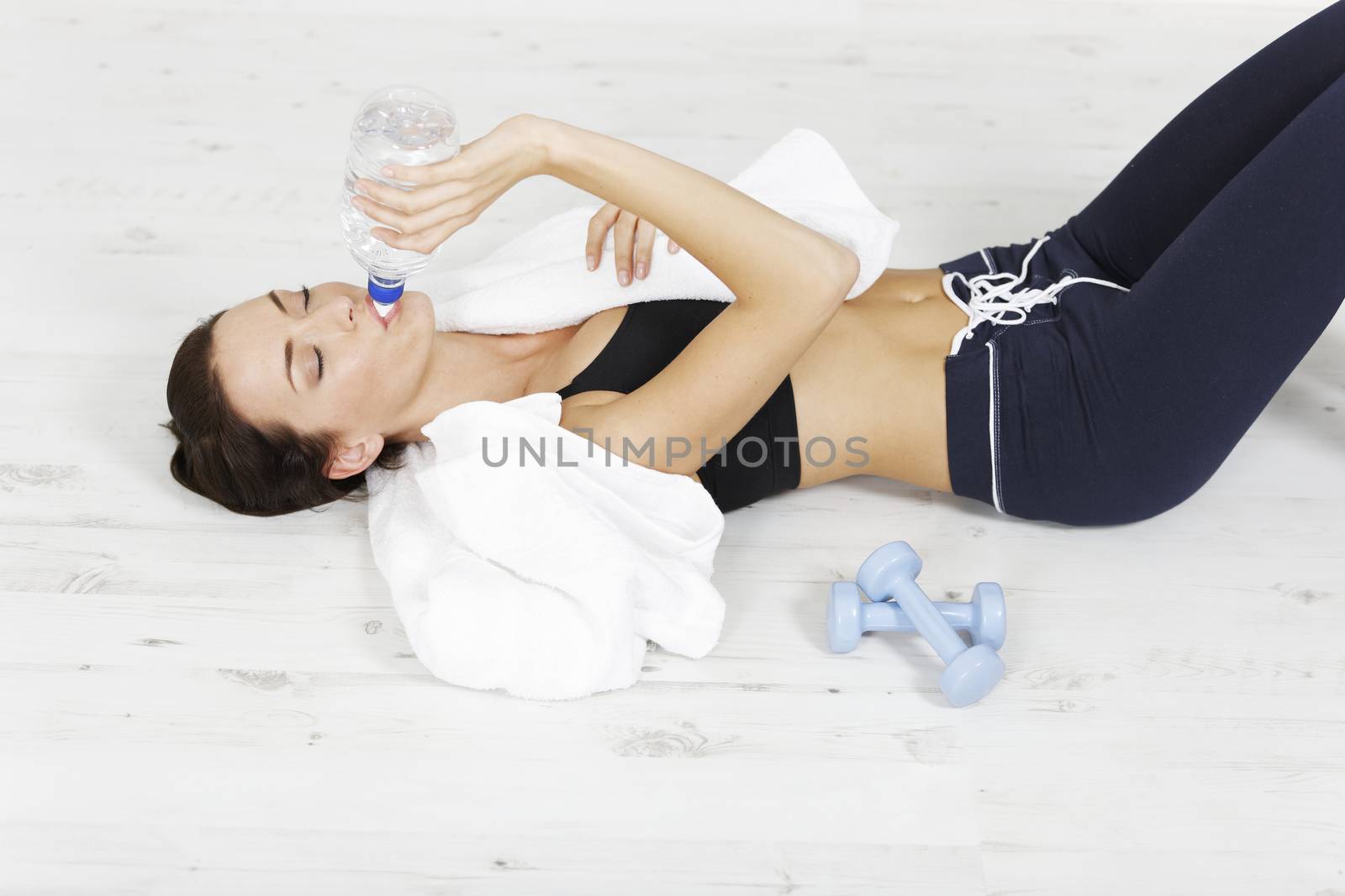 Young woman lying down after long fitness workout.