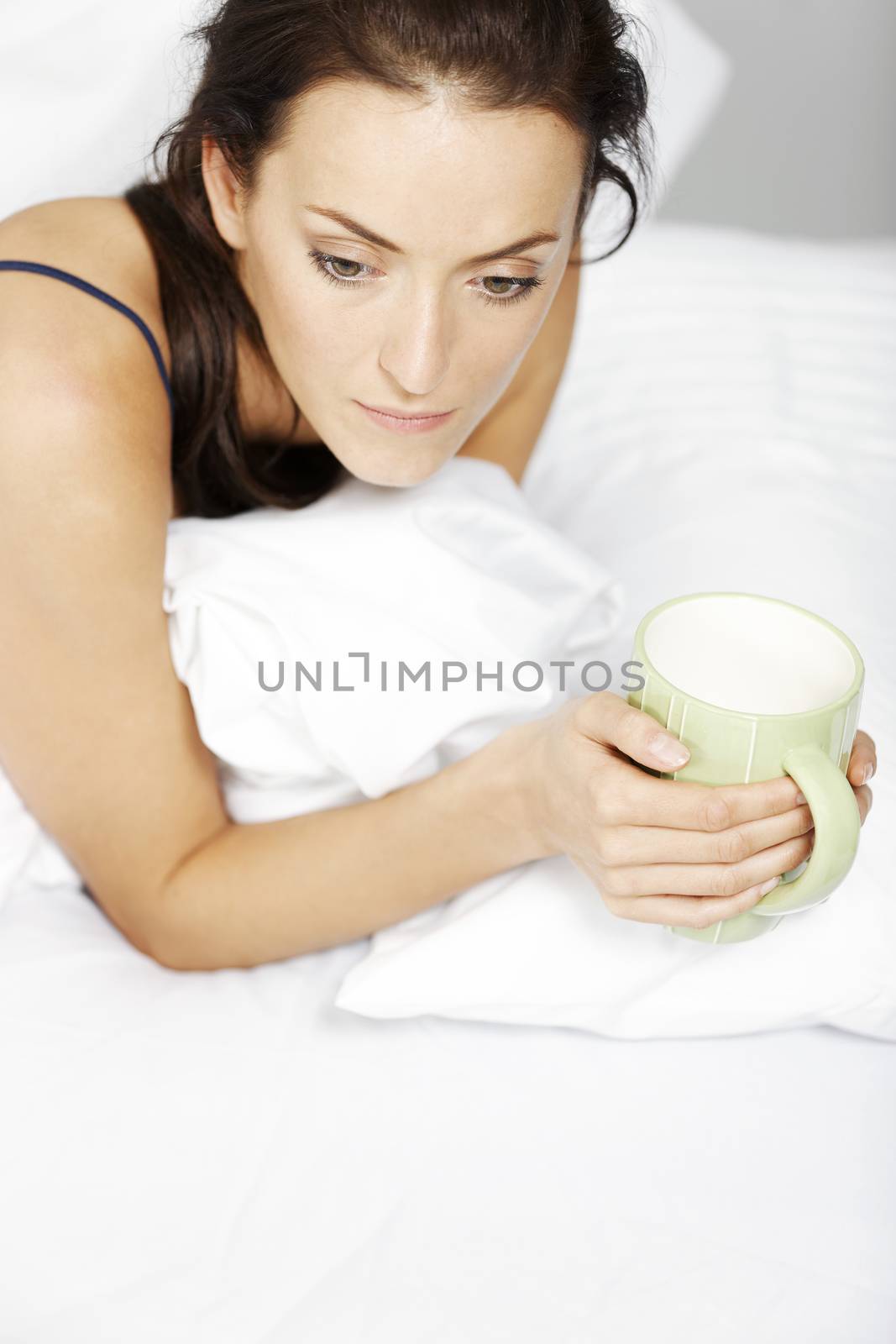 Young woman enjoying a coffee in bed
