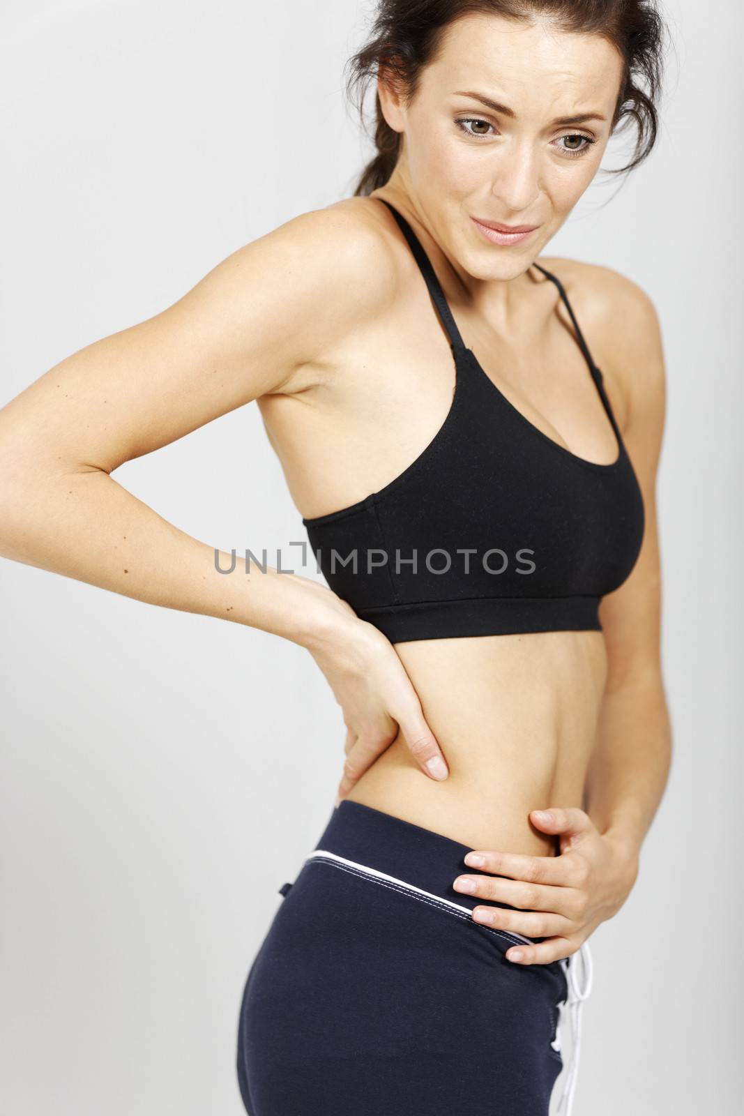 Young woman with muscle pain after fitness workout.