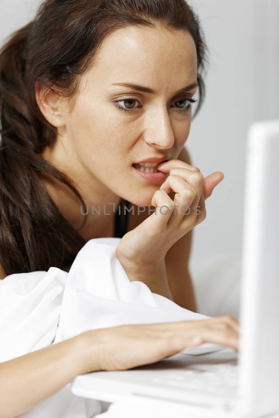 Young woman using her laptop in bed
