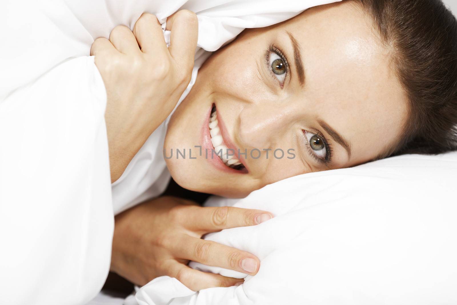 Young woman all cosy and warm in her bed.