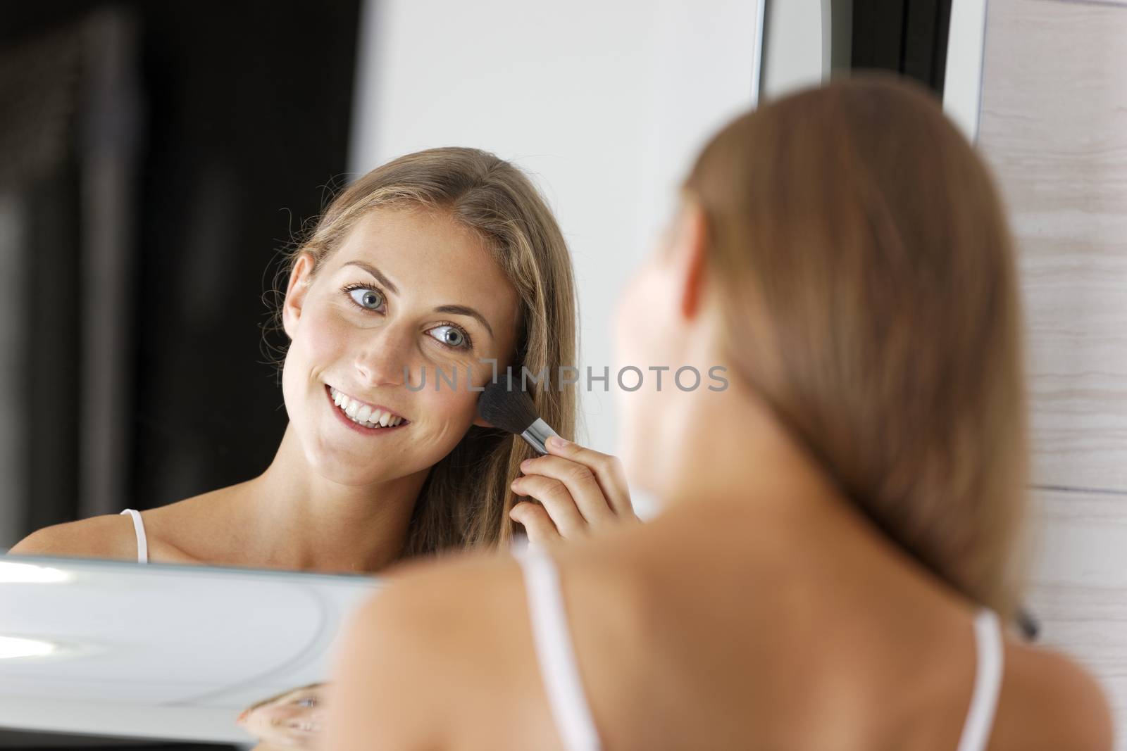 Woman applying makeup by studiofi