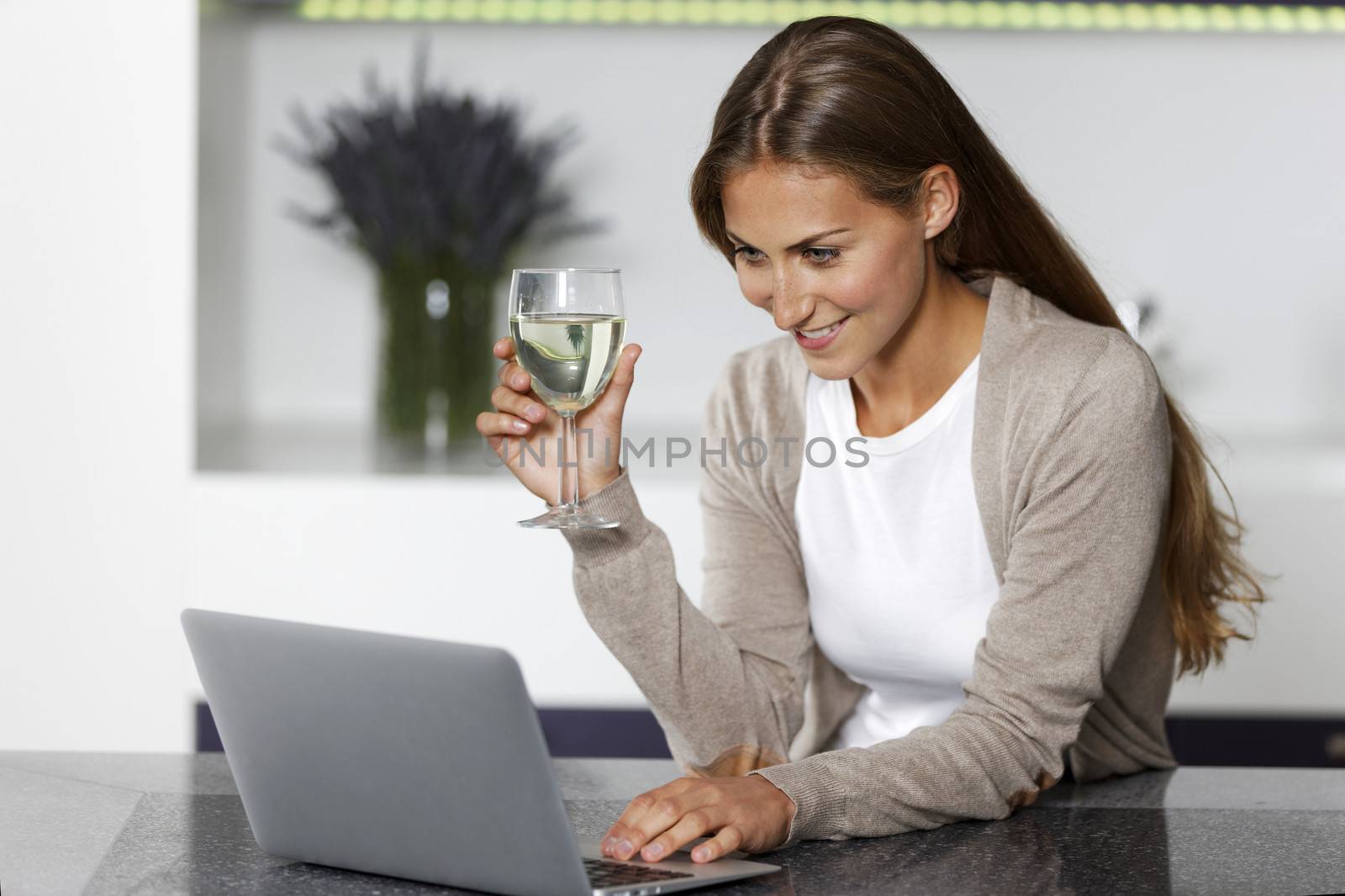 Woman using laptop at home by studiofi