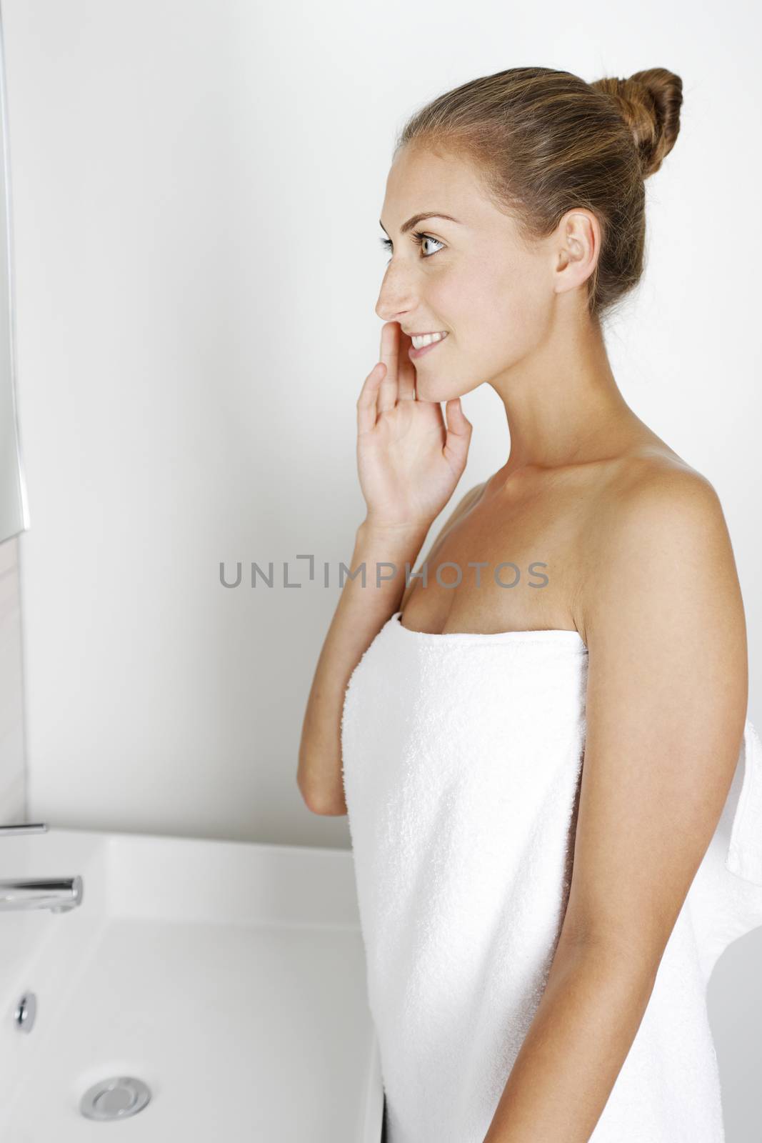 Attractive young woman in her bathroom getting ready.