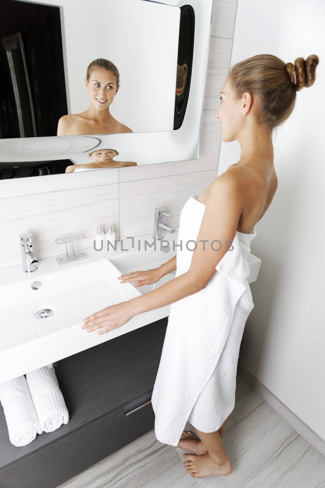 Woman getting ready in bathroom by studiofi