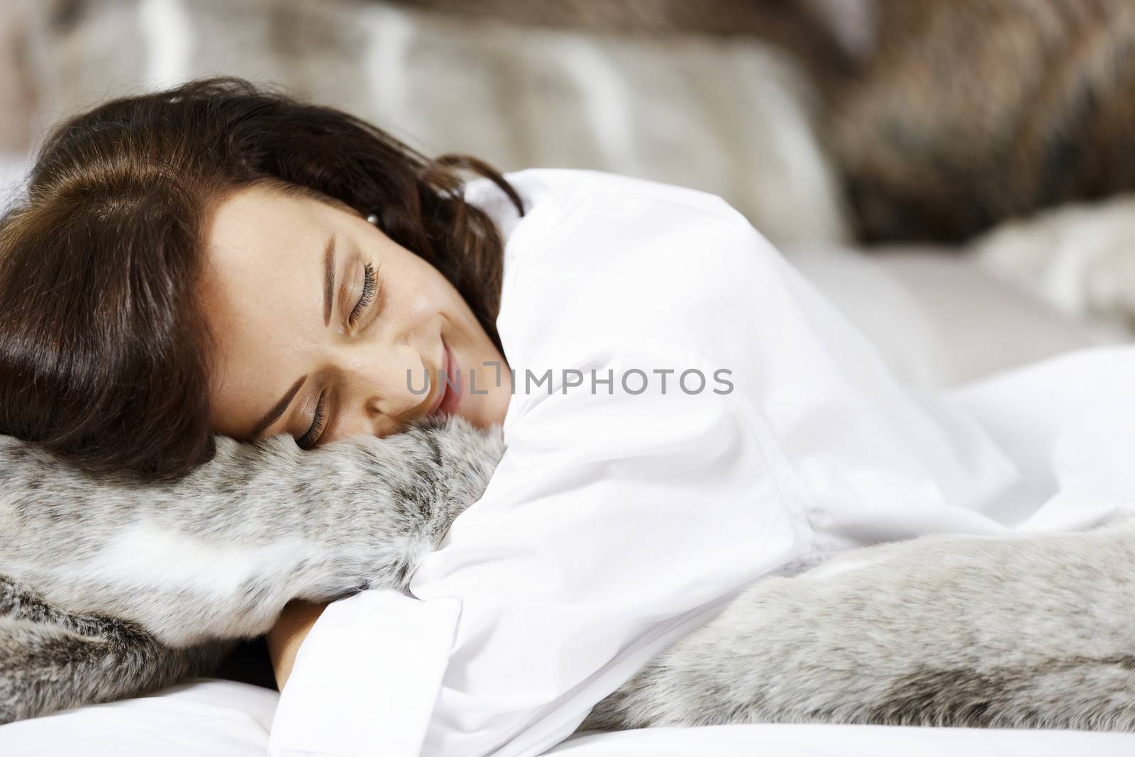 Beautiful young woman relaxing on her bed.