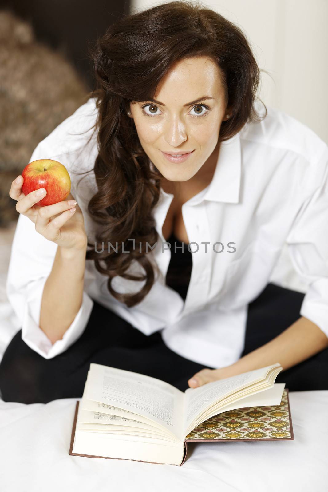 Woman reading book in bed by studiofi