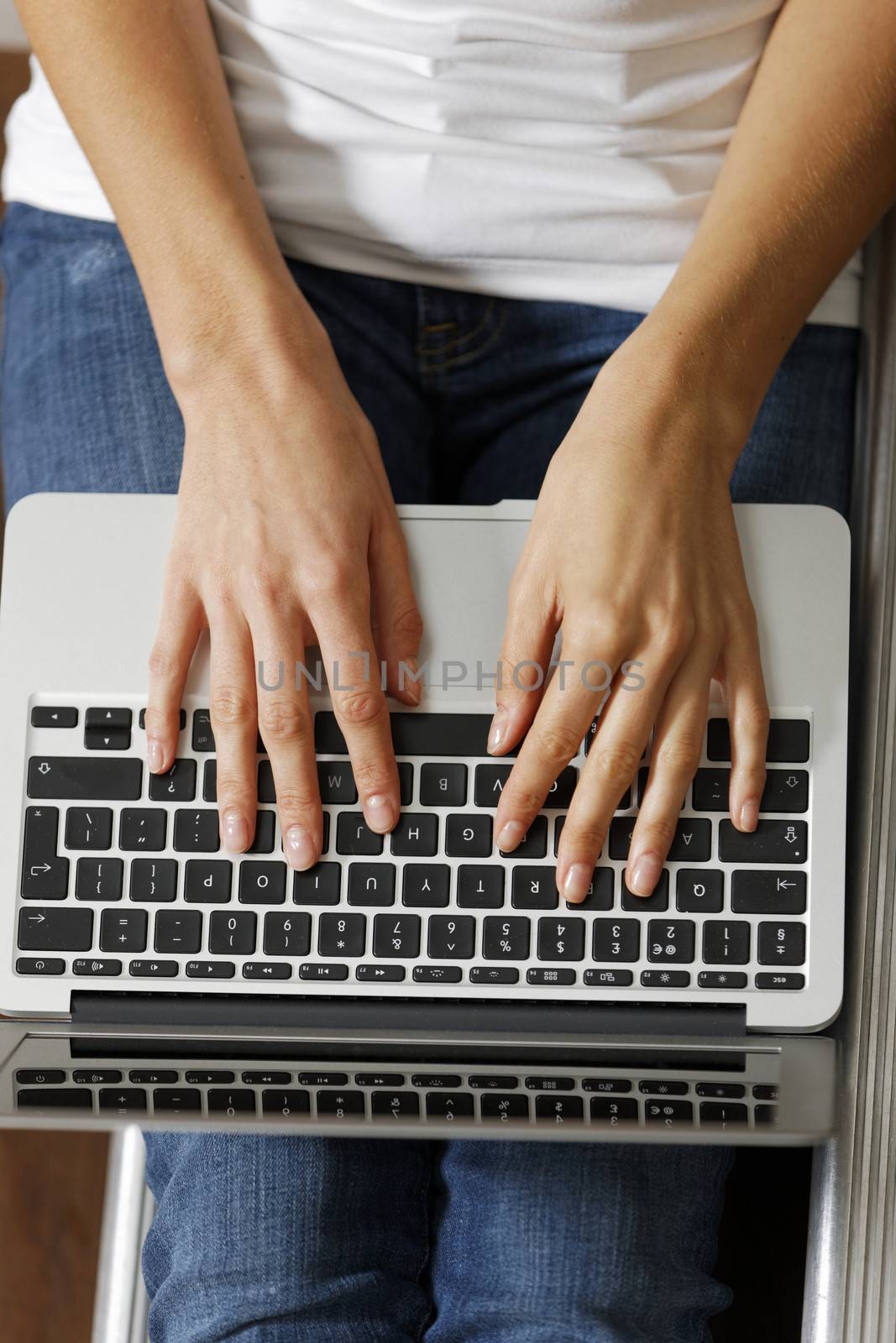 Woman typing on laptop by studiofi