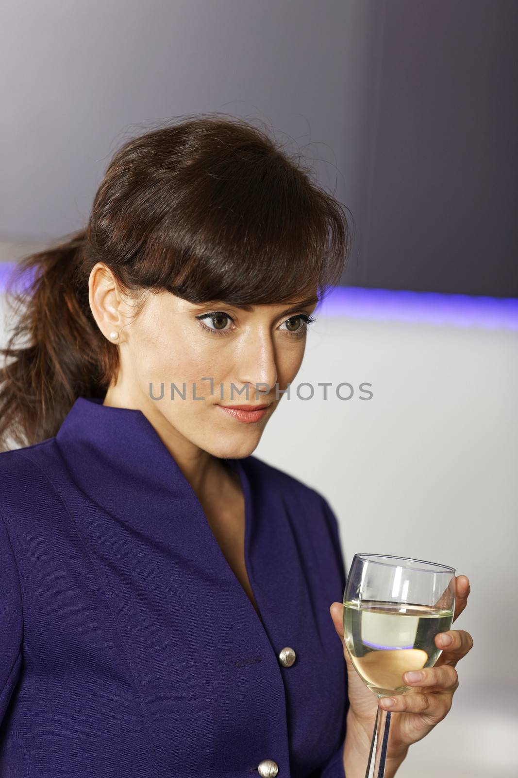 Smart business woman relaxing in her kitchen with a glass of wine.