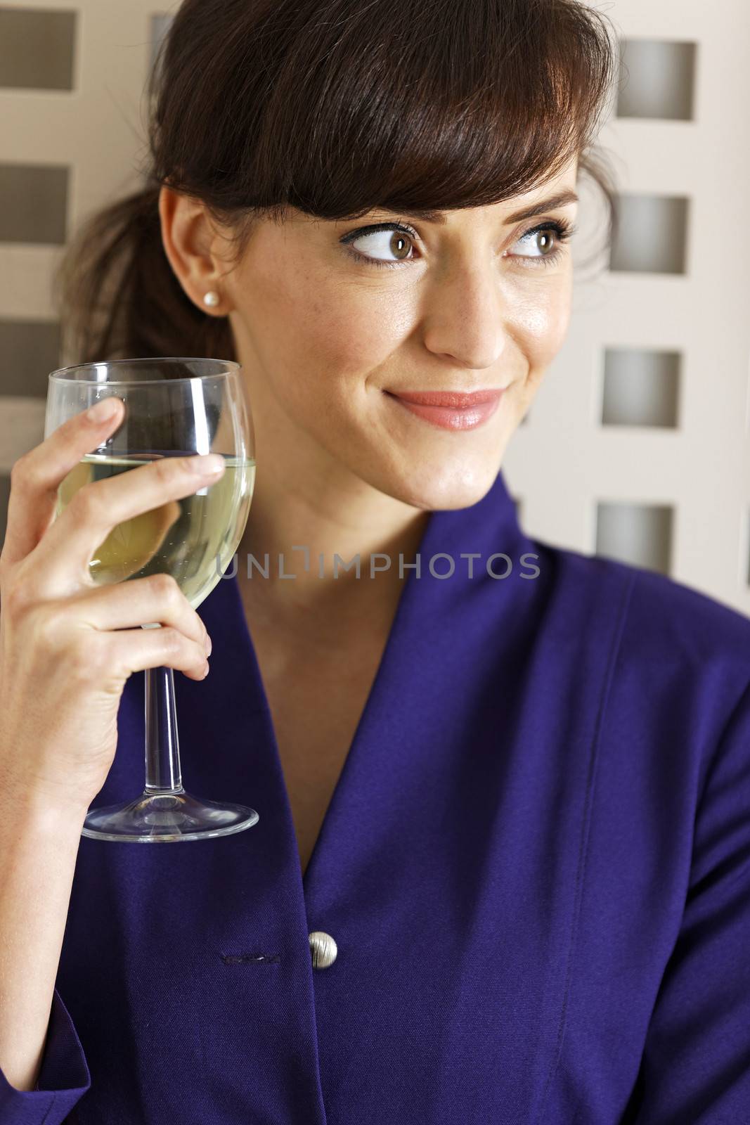 Woman enjoying a glass of wine by studiofi