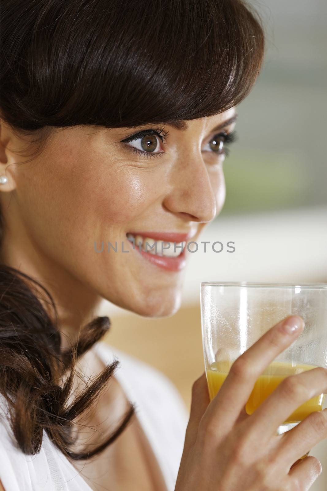 Beautiful young woman enjoying a glass of juice.