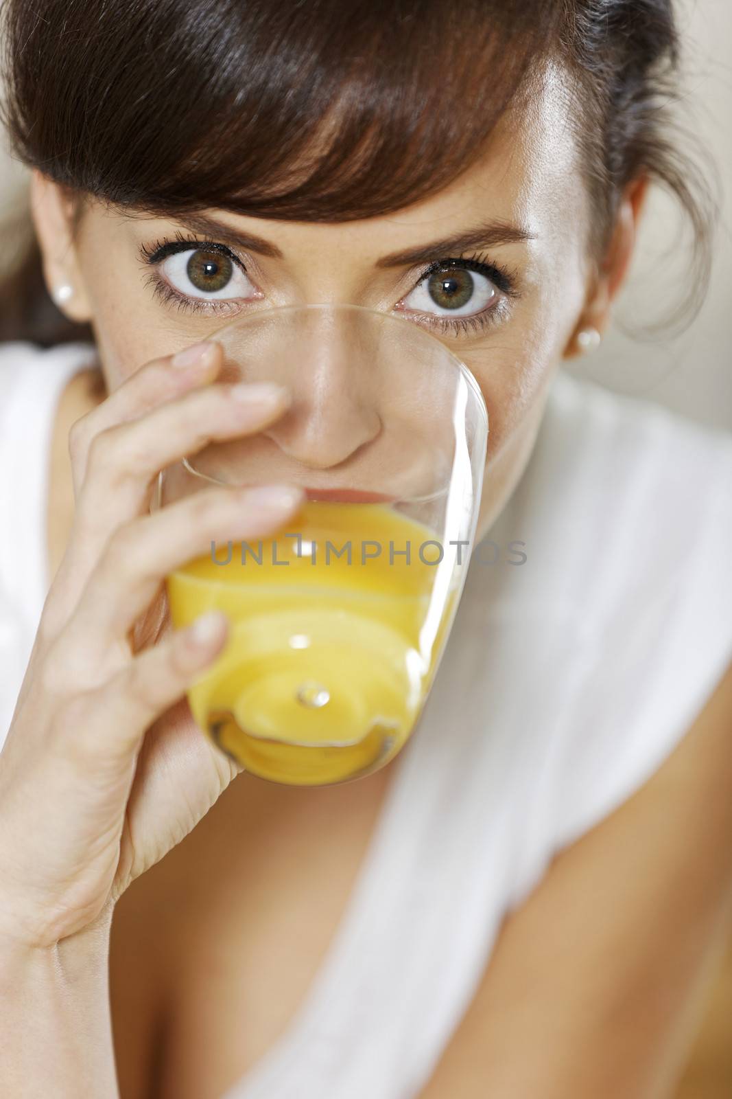 Beautiful young woman enjoying a glass of juice.