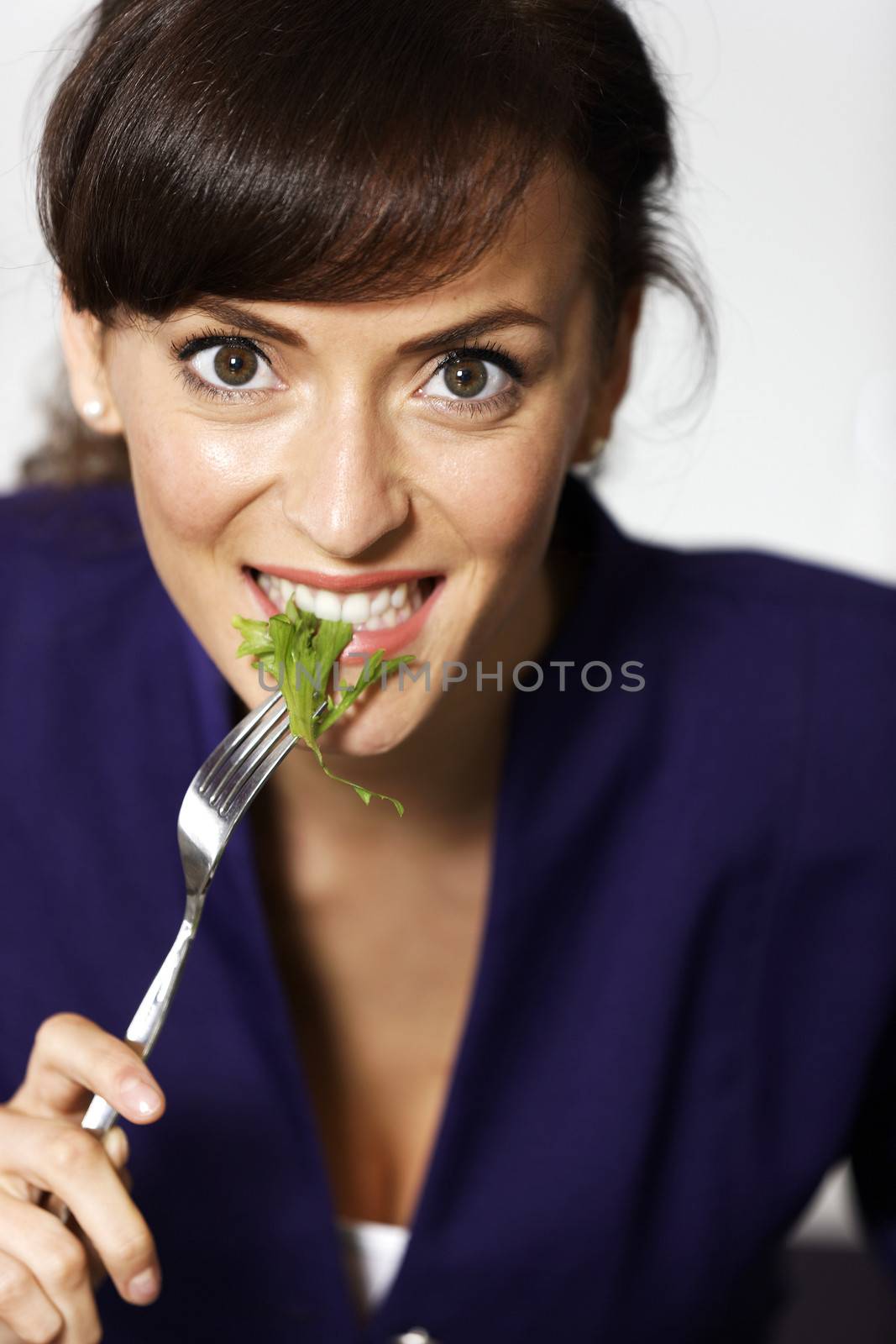 Woman eating fresh salad by studiofi