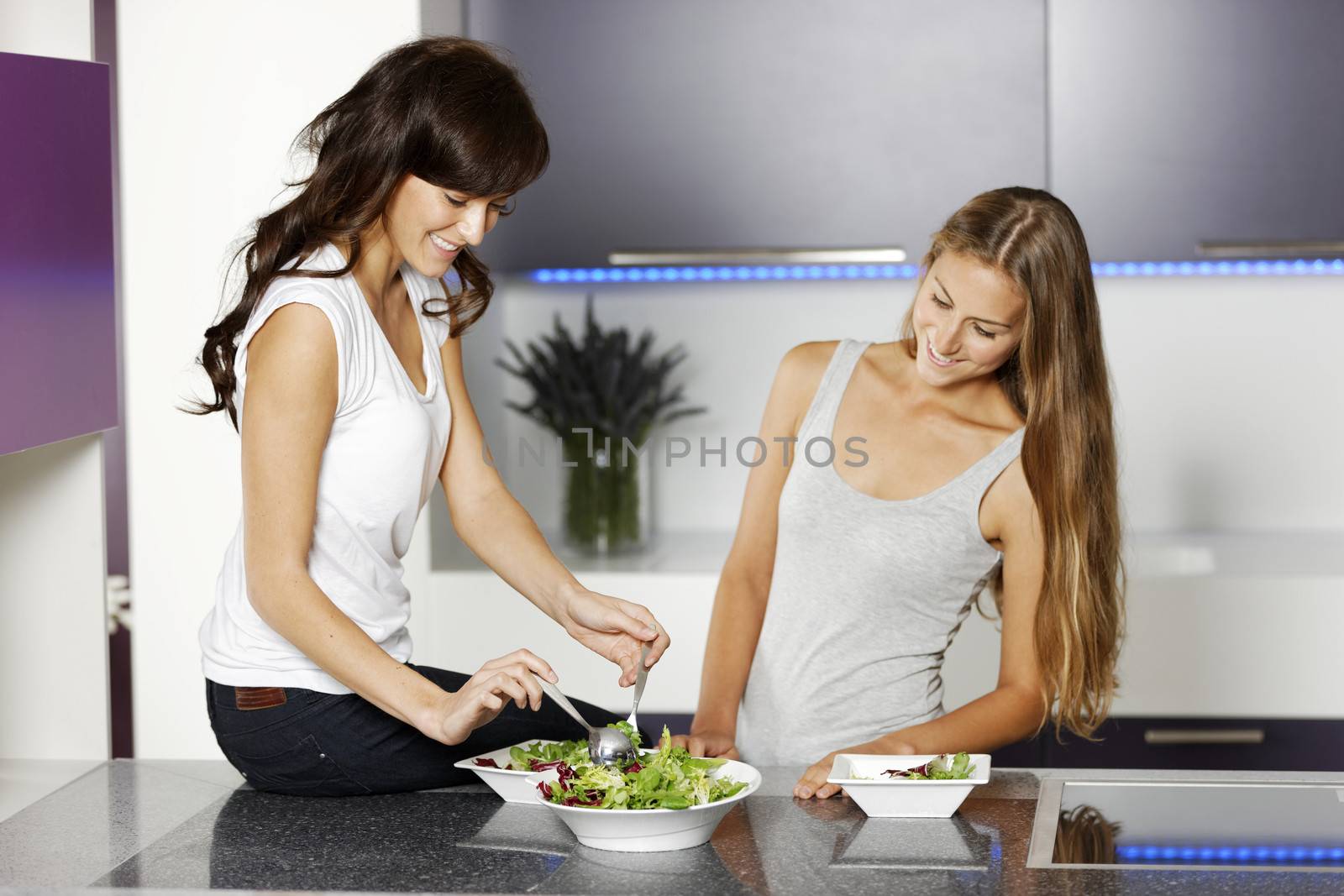 Two friends making salad by studiofi