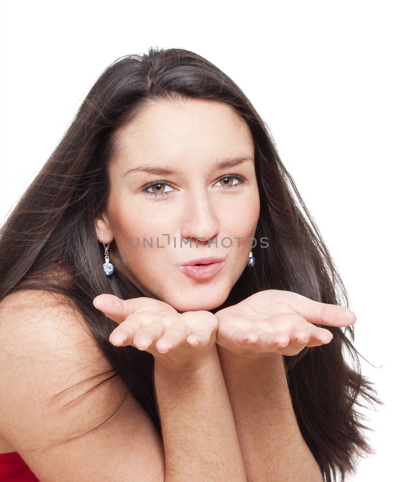 young girl sending away a kiss by blowing into her hands - isolated on white
