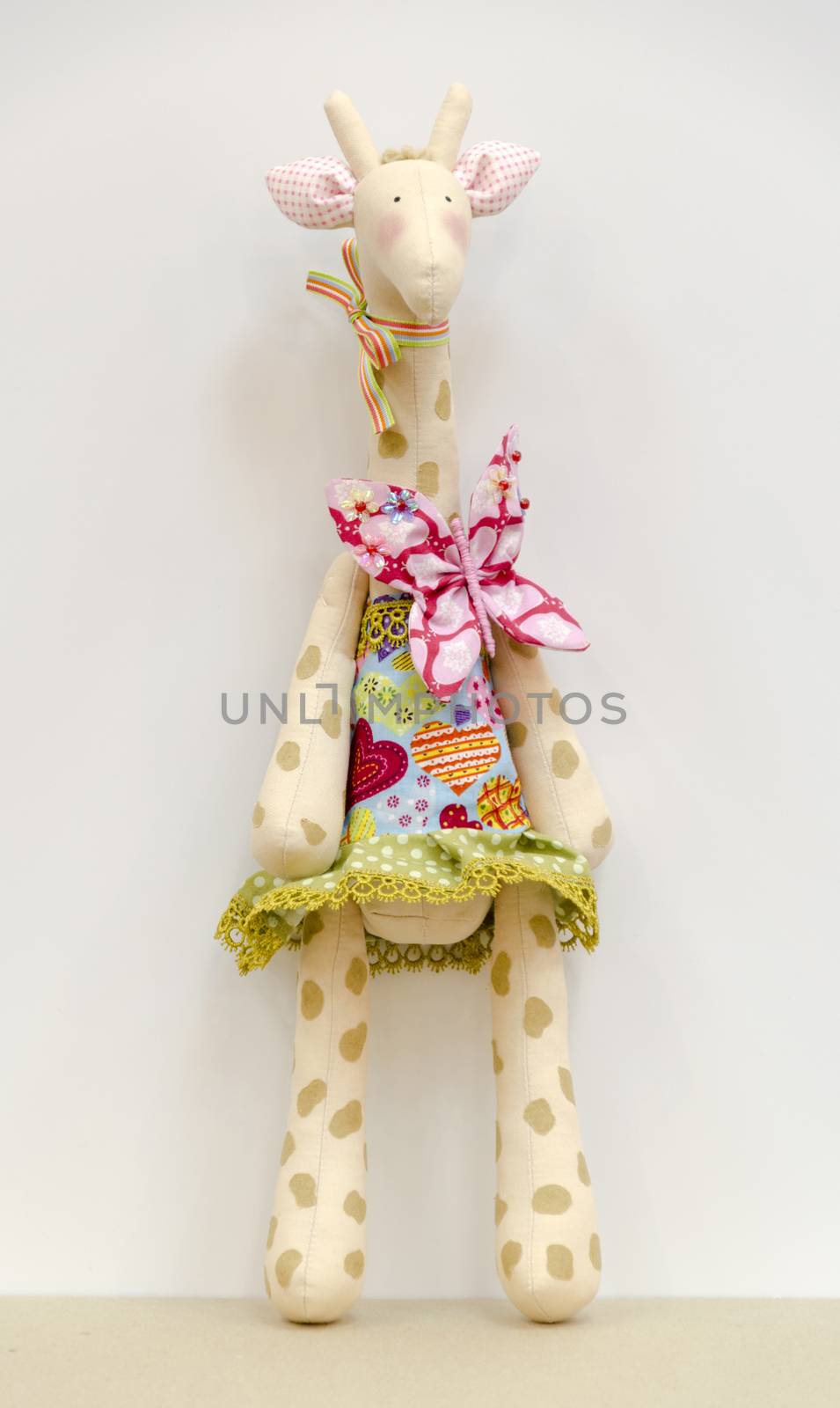 Hand made soft toy giraffe in a dress standing by pt-home