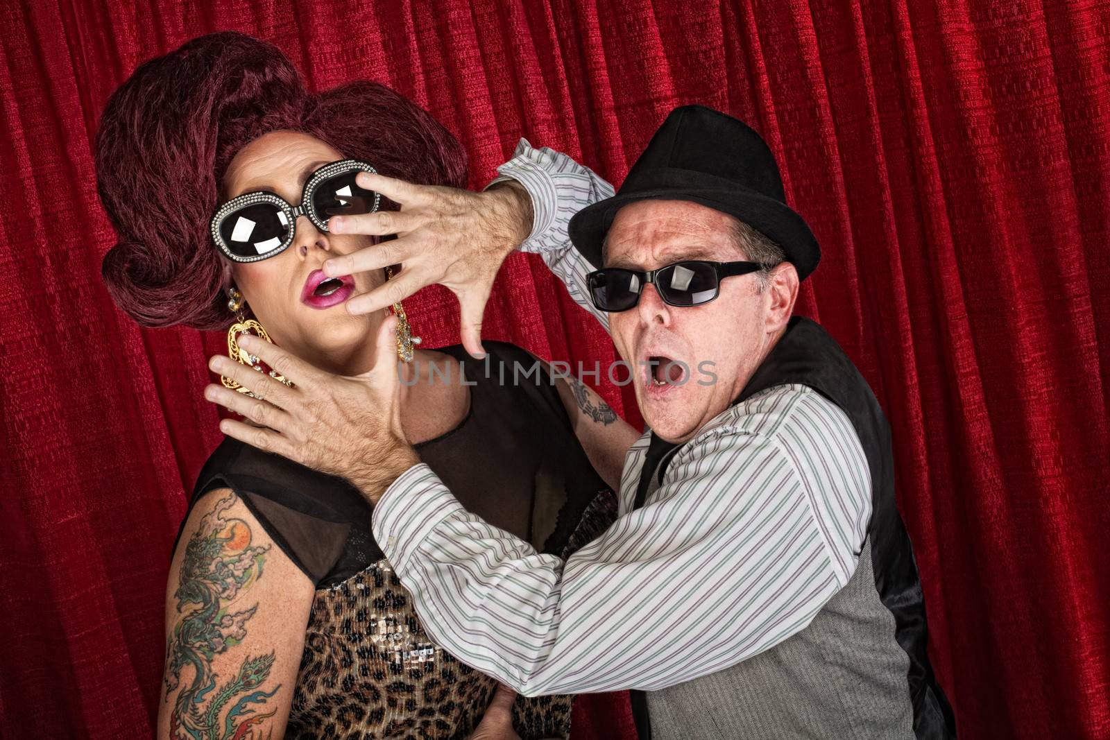 Surprised drag queen and partner in sunglasses