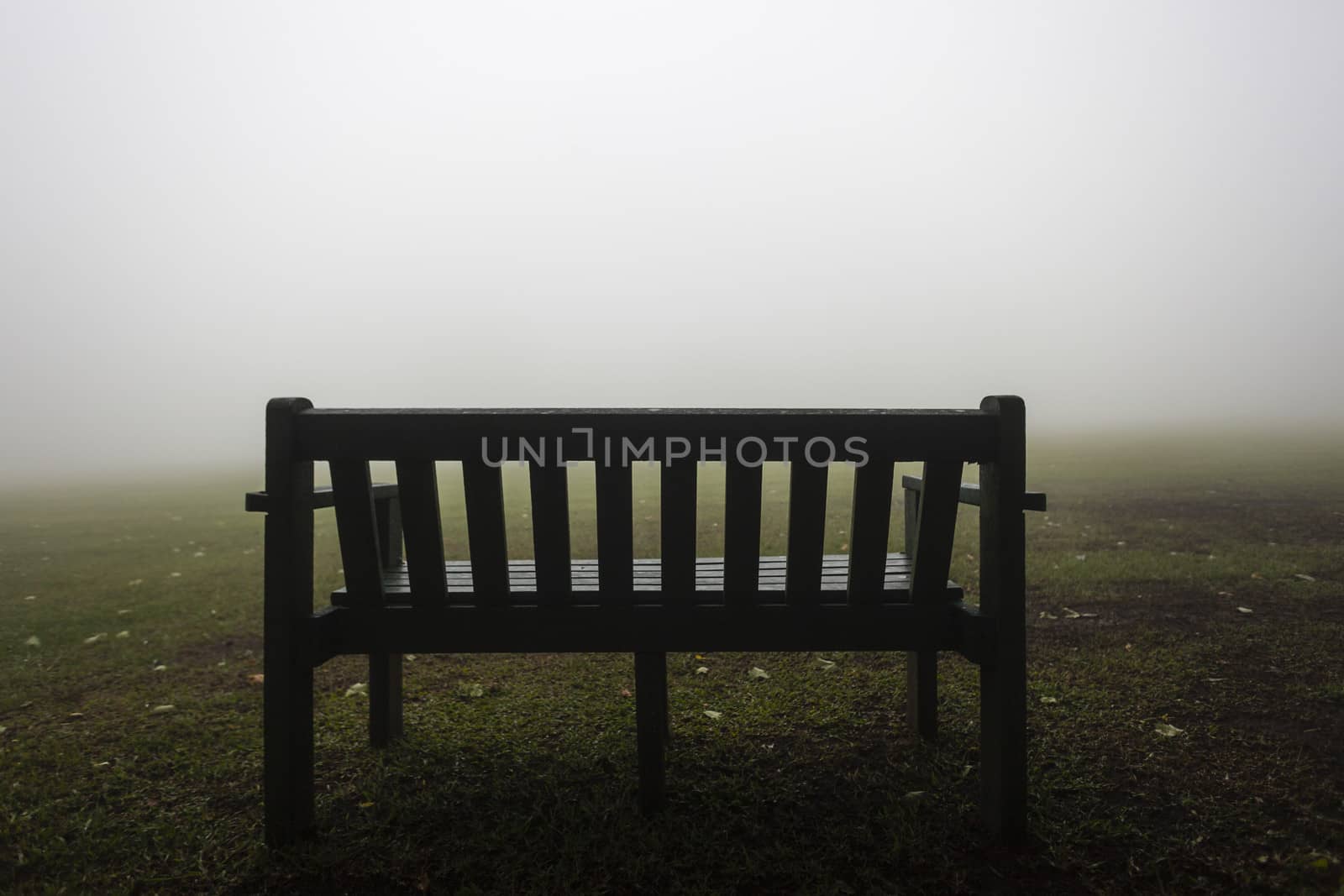 Bench for spectators viewing season mist over sports field.