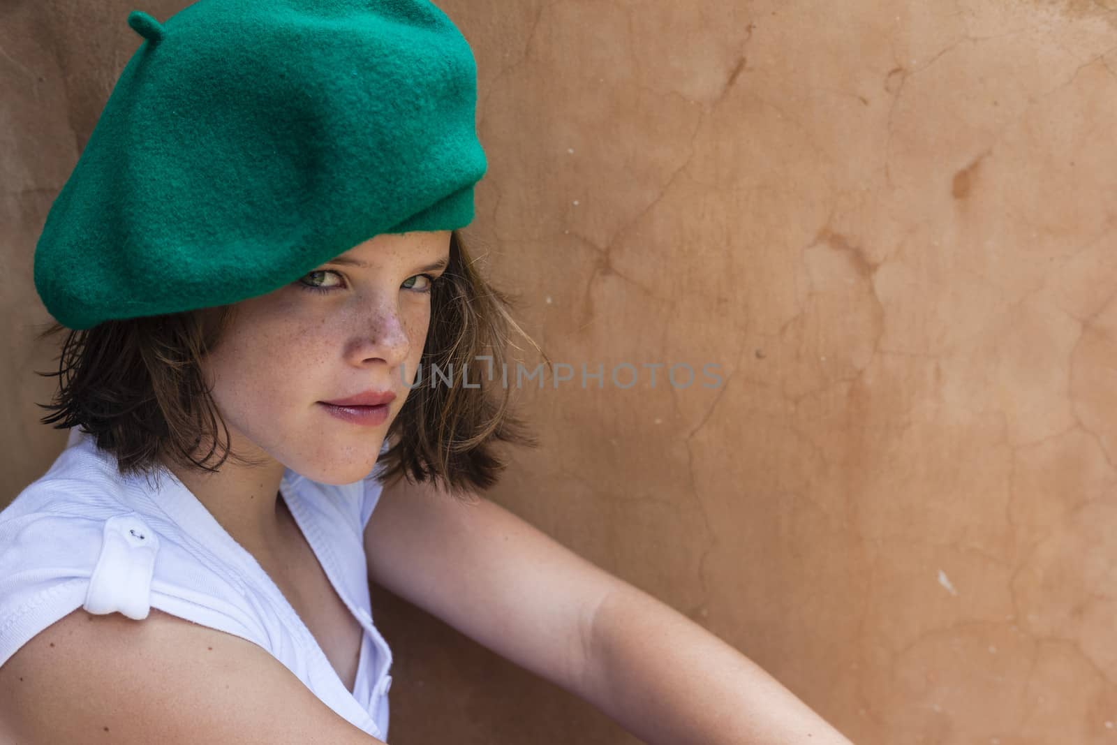 Young girl mood wearing green beret hat.