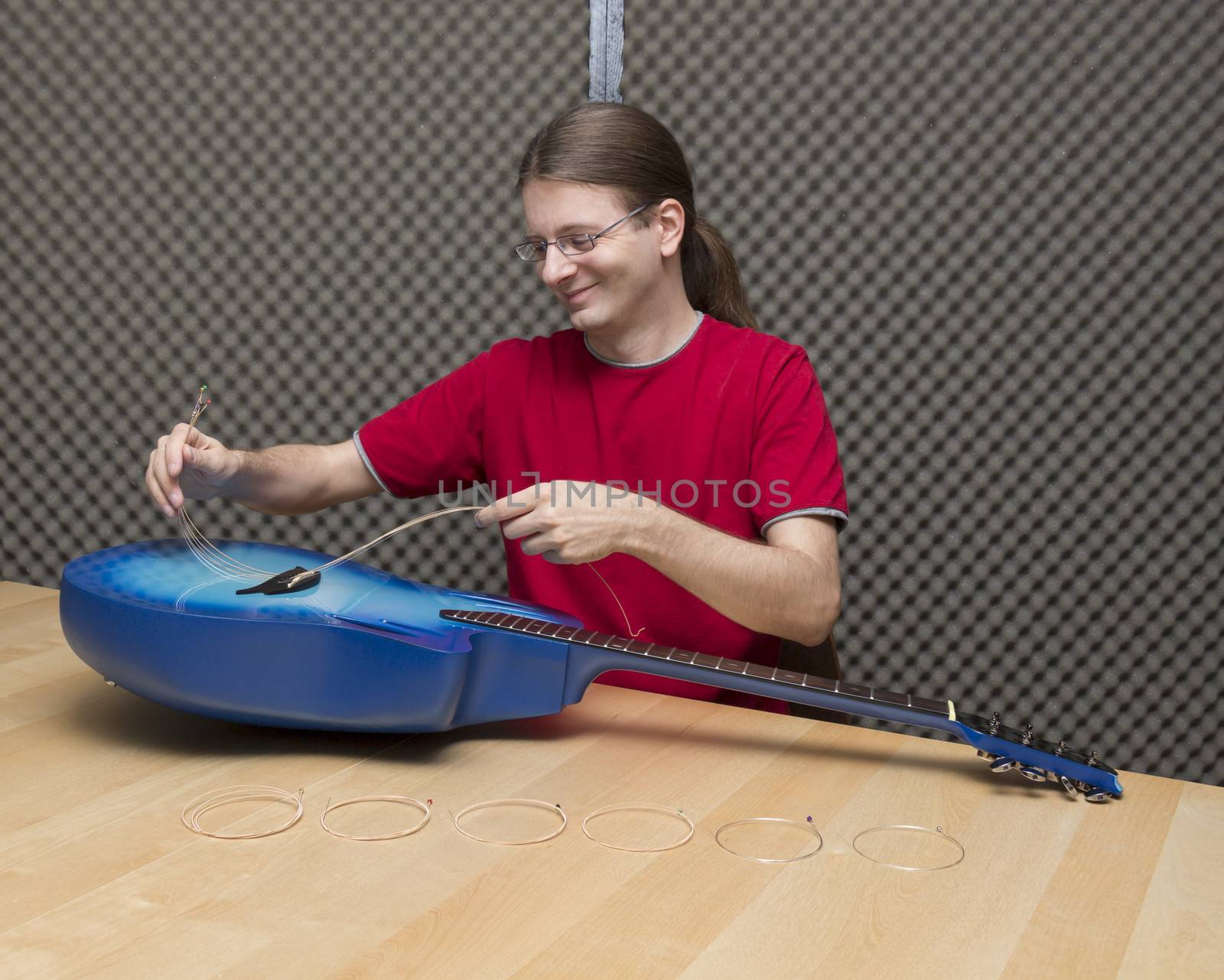 Guitarist pulling the old strings of a guitar out ( Series with the same model available)