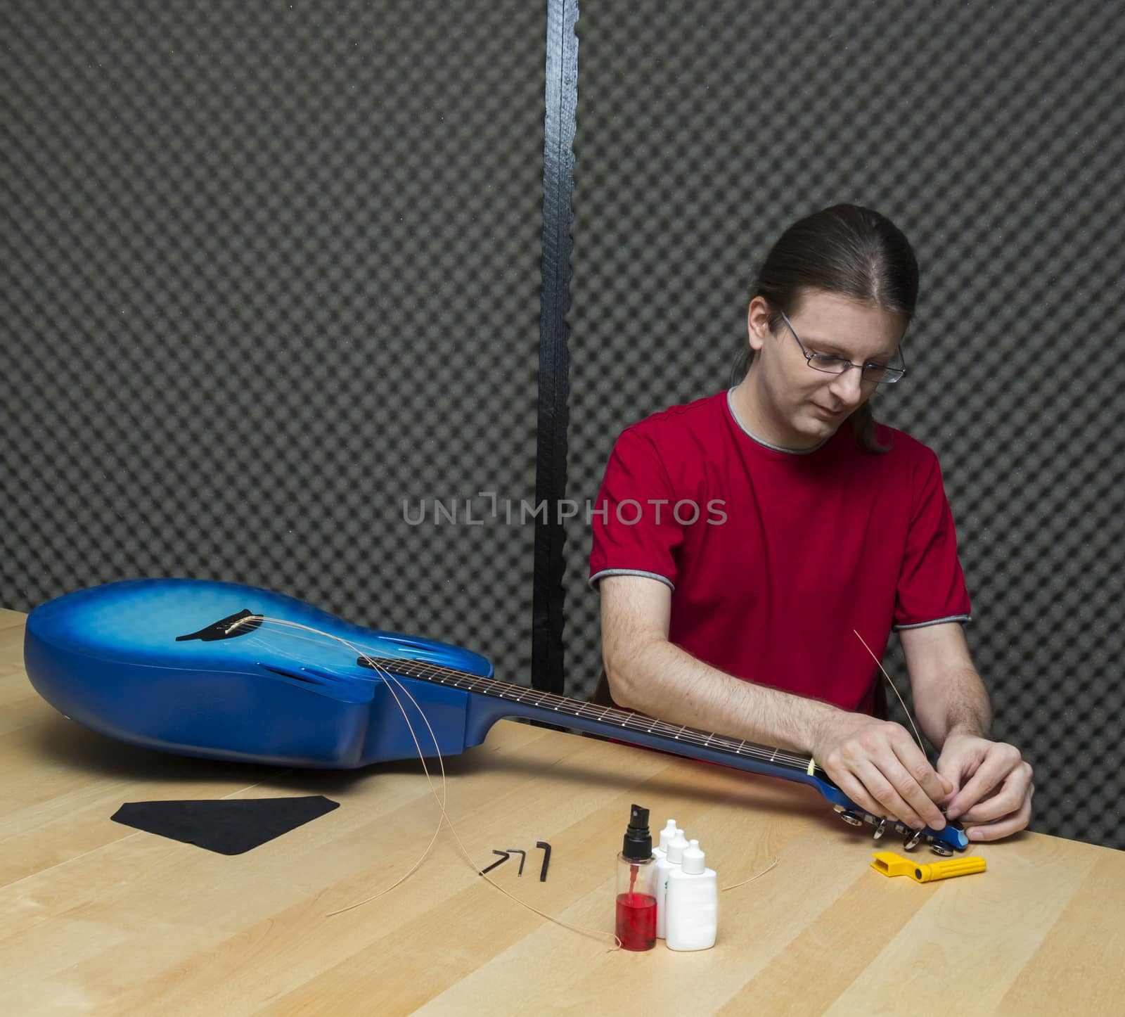 Guitar technician replacing the strings of an electro-acoustic guitar ( Series with the same model available)