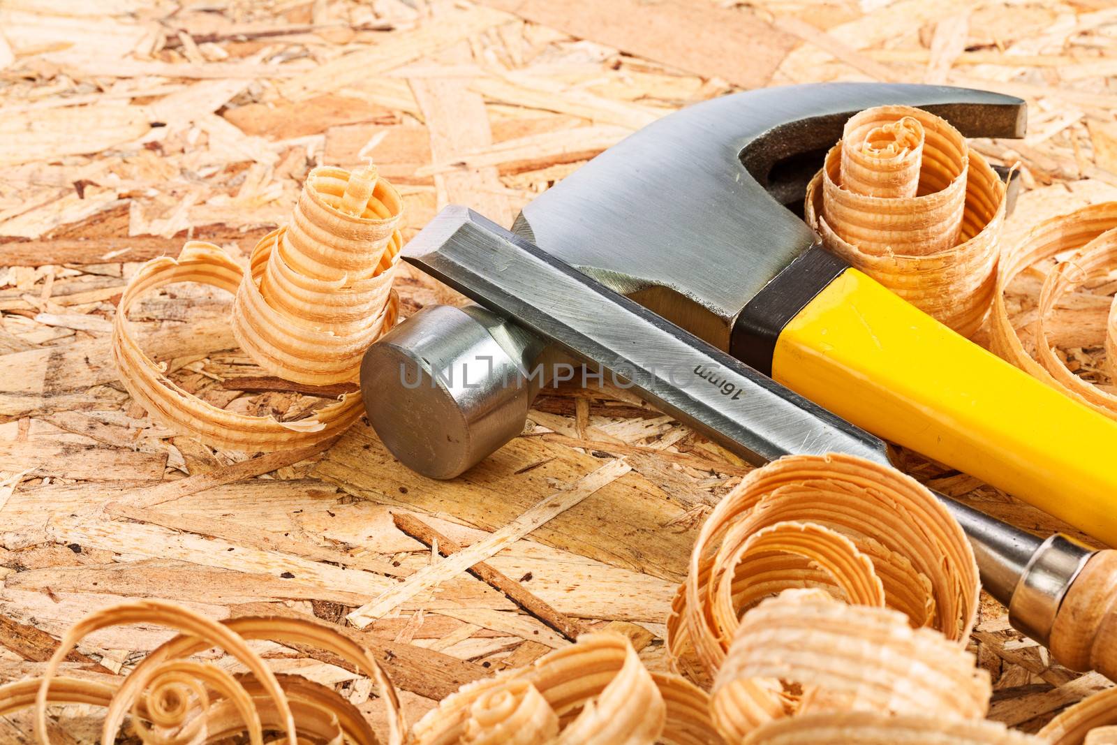 claw hammer and carpenter chisel with wooden chips