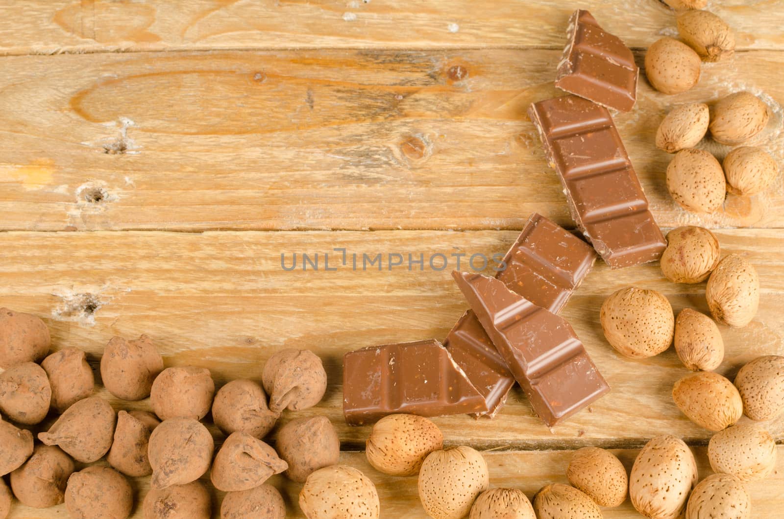 Nuts and chcolate displayed on a rustic wooden background