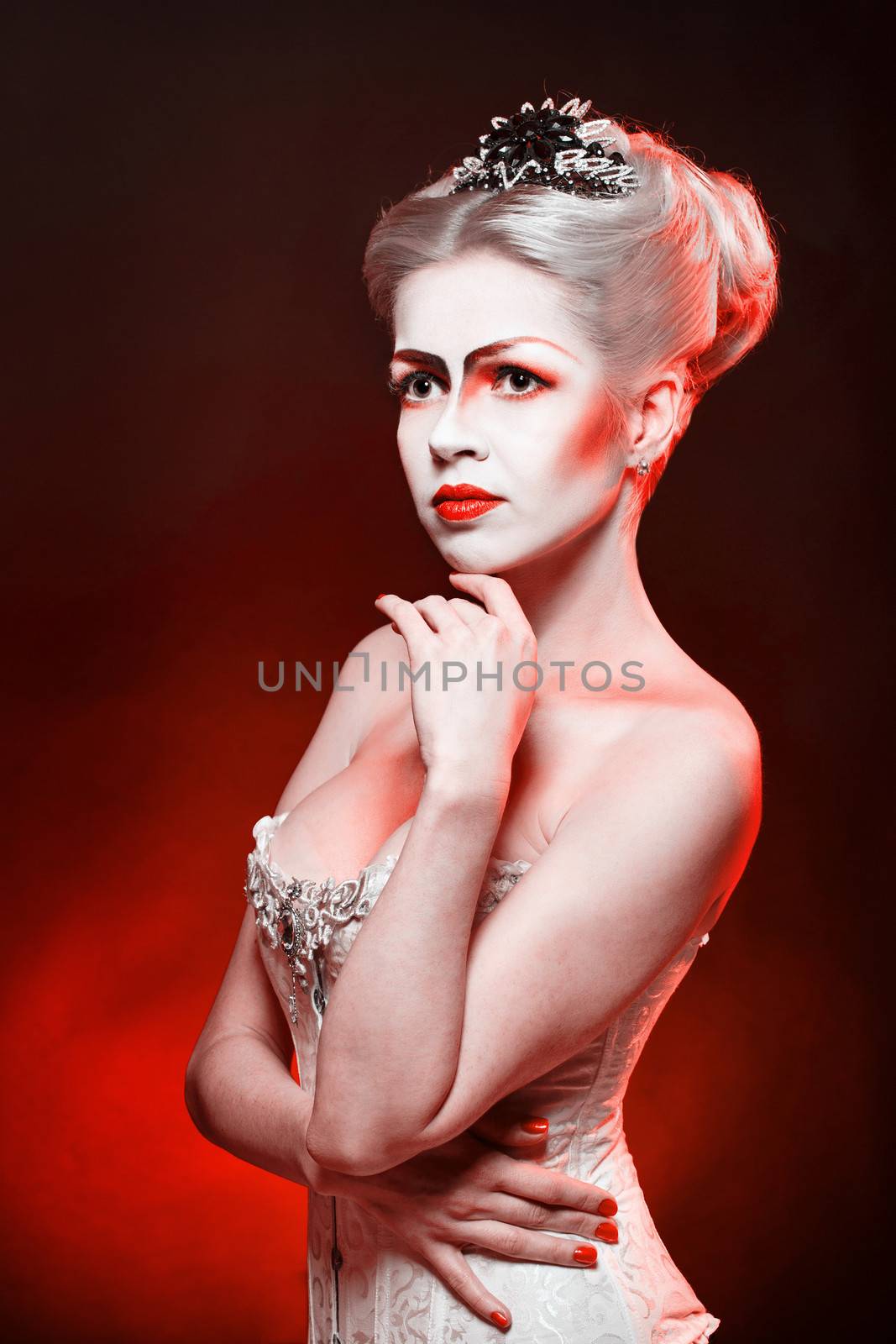 Red Queen with a crown and a corset, with make-up in studio shot