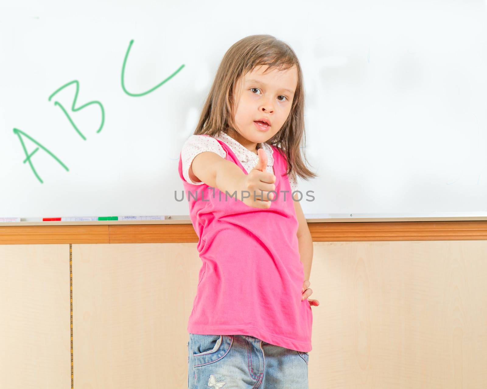 Young girl by a whiteboard at school