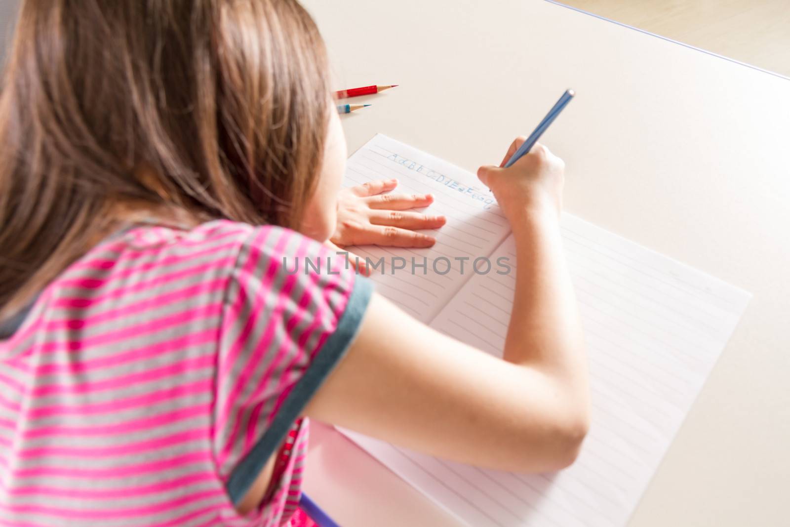 Young girl doing homework in a notebook