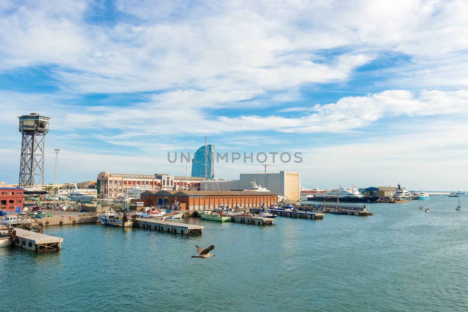 Barcelona, Spain - October 12, 2013: View at the Port and W Barcelona, popularly known as the Hotel Vela (Sail Hotel) due to its shape, is a building designed by Ricardo Bofill is located in the Barceloneta district of Barcelona, in the expansion of the Port of Barcelona. 