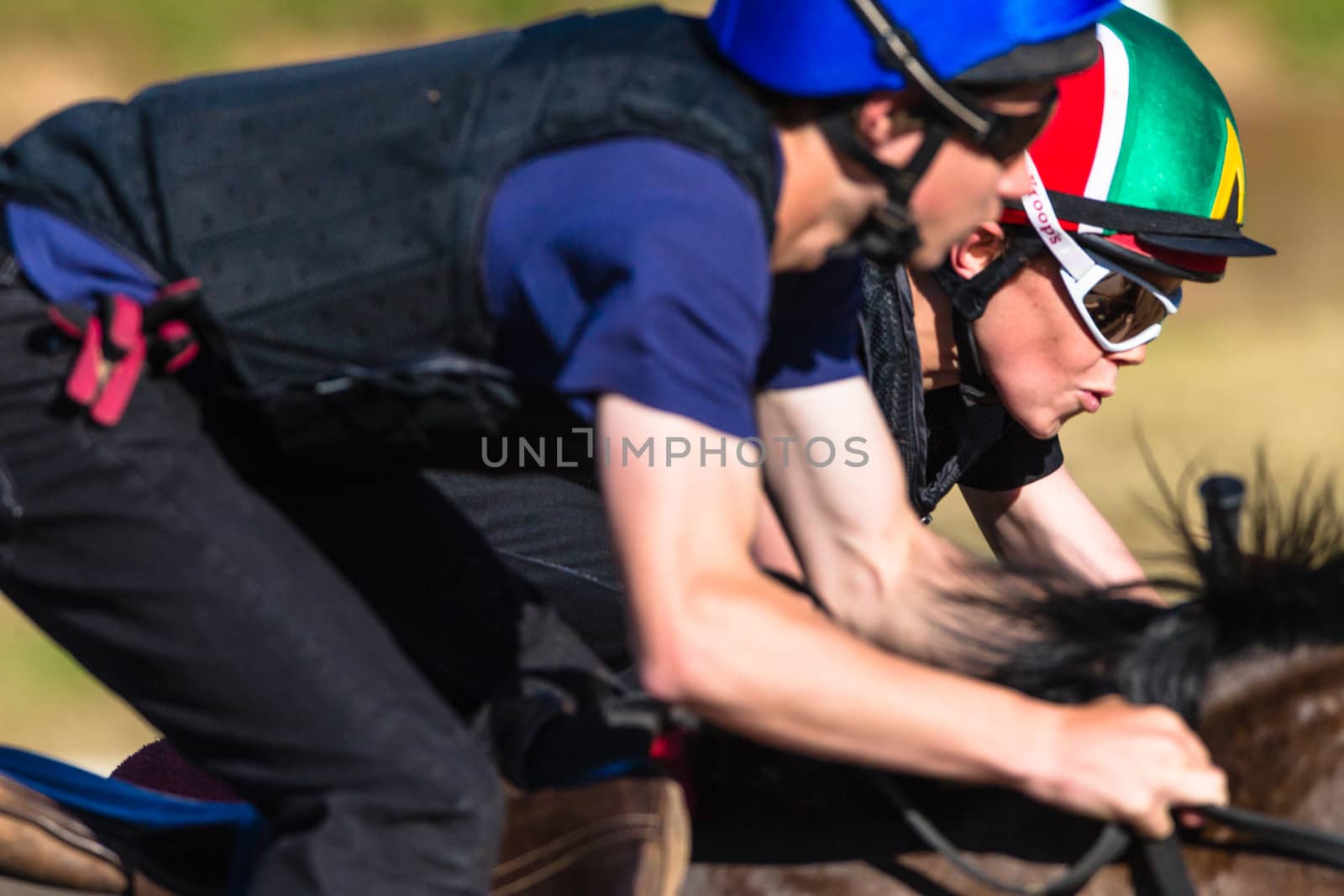 Jockeys close focus detail riding focusing on race horse galloping on sand track training