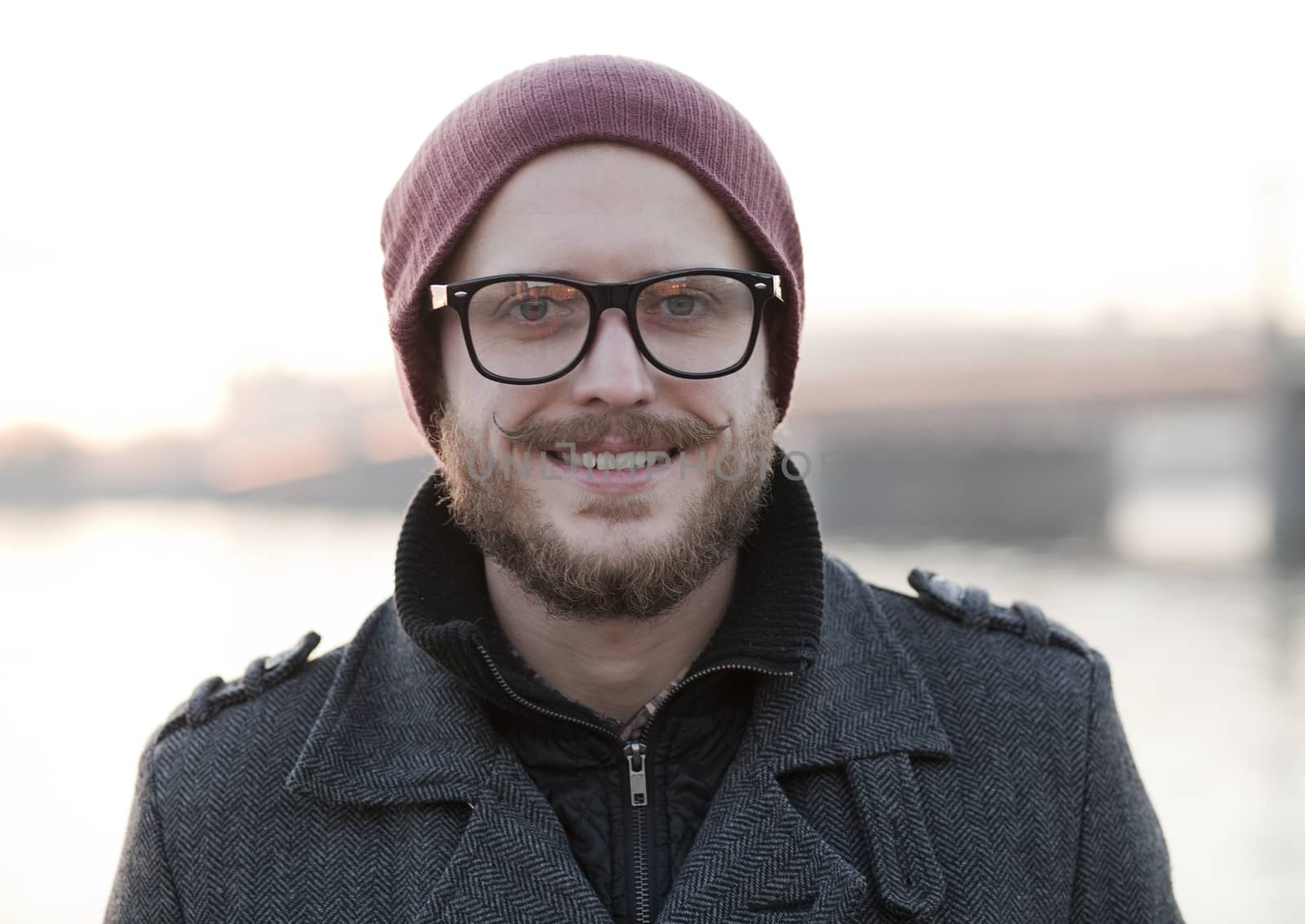 Portrait of young smiling hipster with moustache and beard