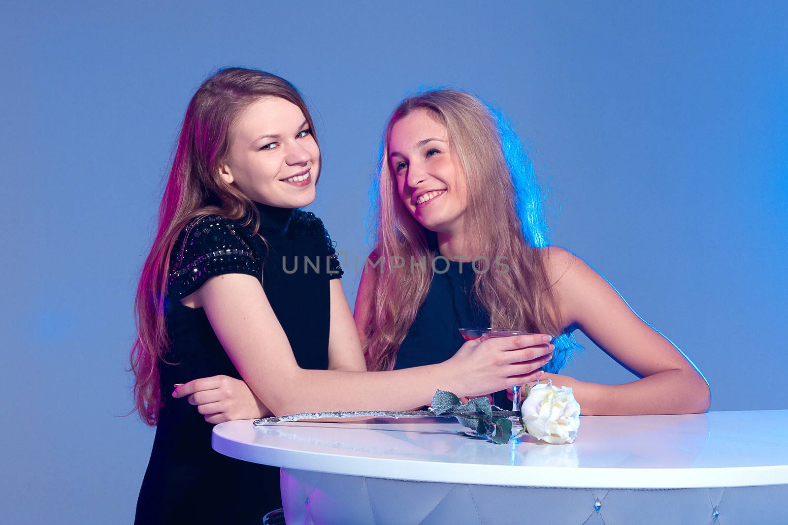 Happy beautiful girls with a drink in nightclub