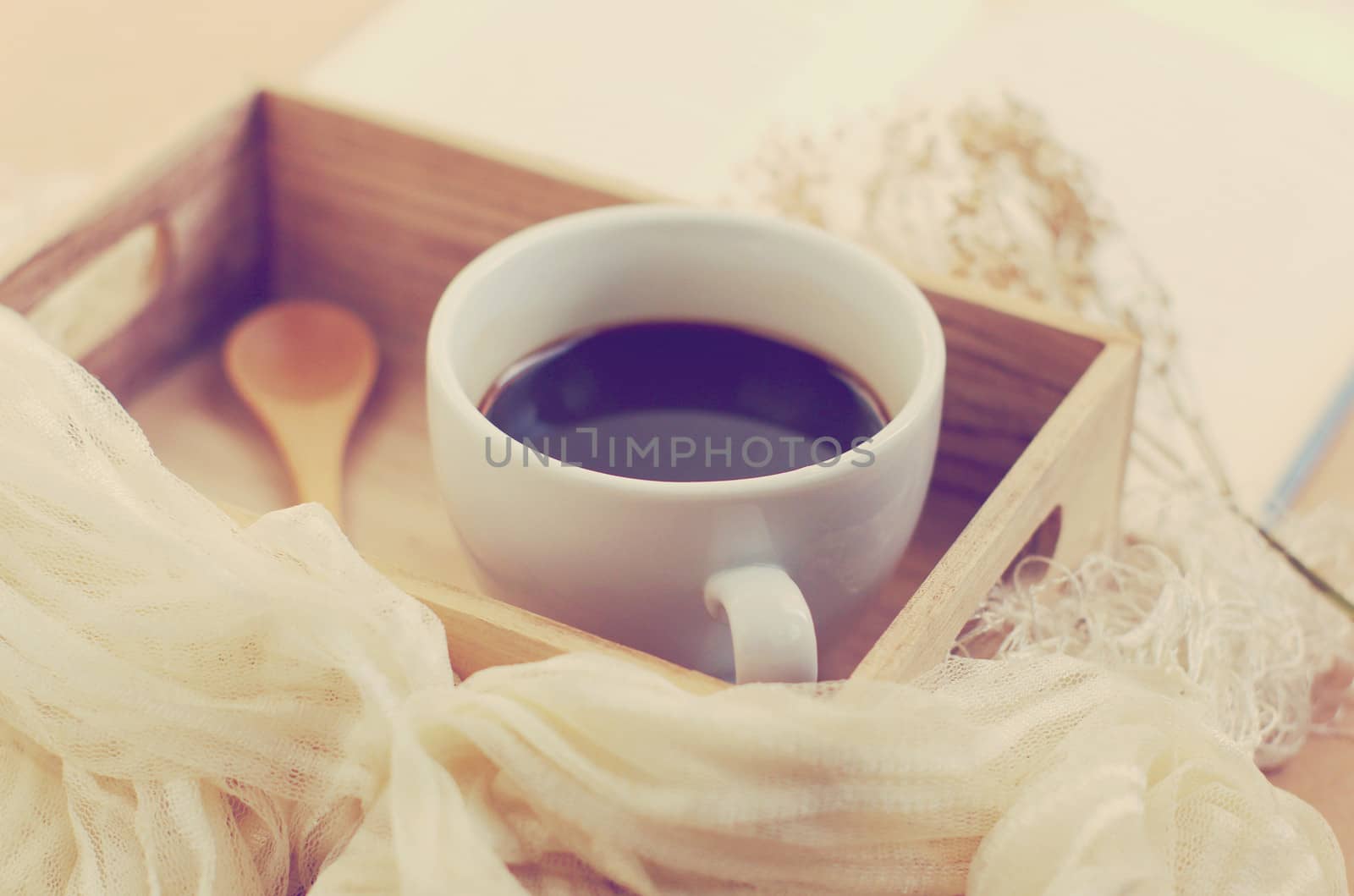 Black coffee and spoon on wooden tray, retro filter effect by nuchylee