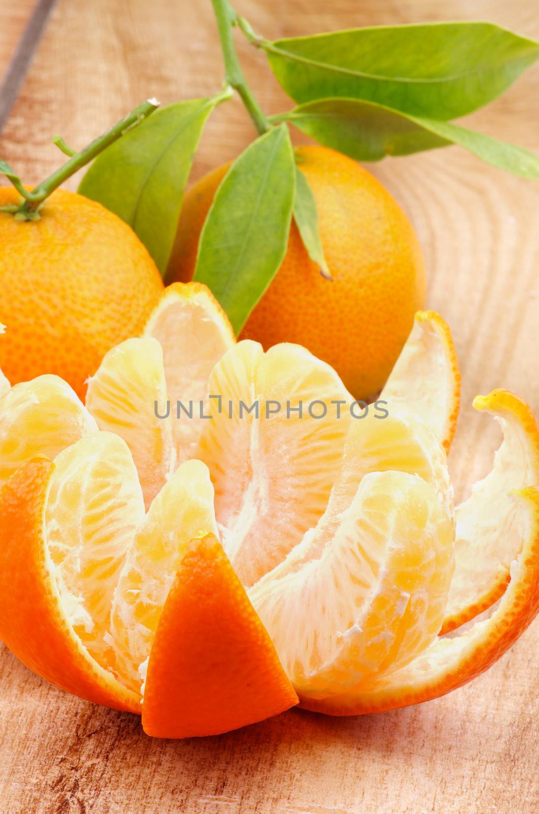 Fresh Ripe Tangerine Full Body with Leafs and  Segments with Citrus Peel closeup on Wooden background