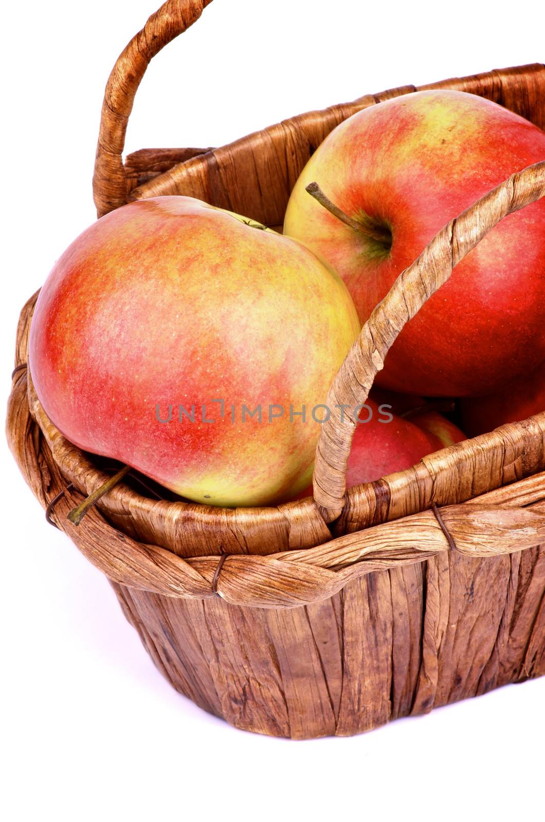 Delicious Ripe Red Apples in Wicker Basket closeup on white background