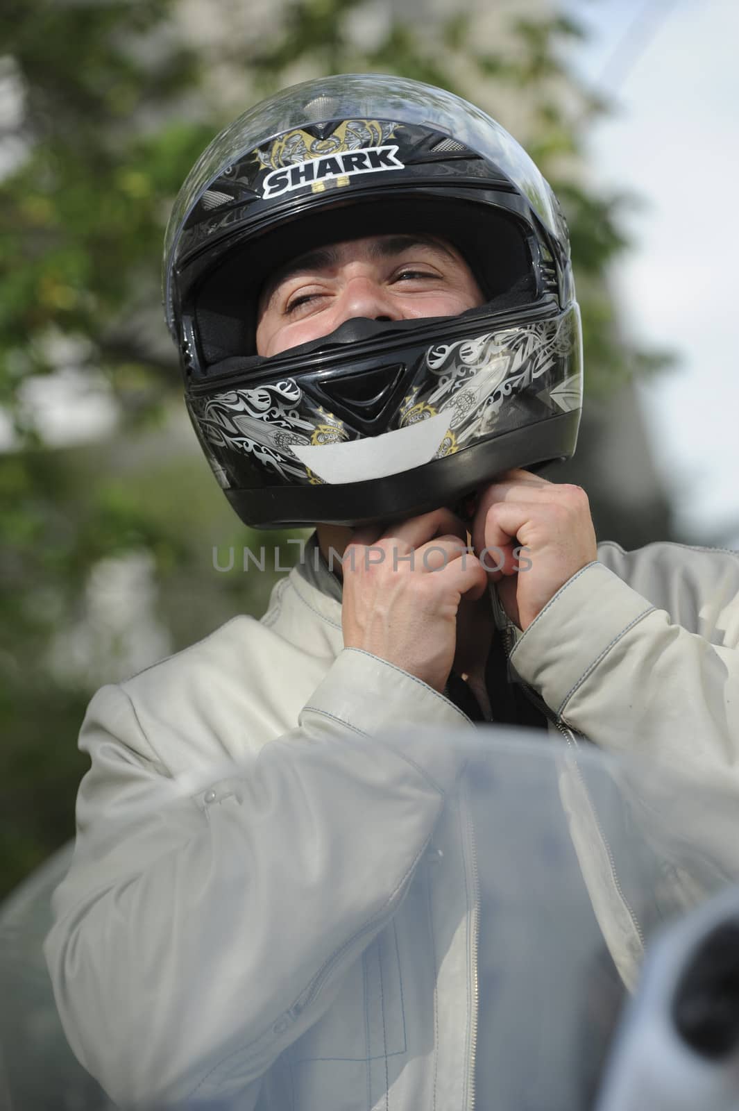 Young man with motorcycle putting the helmet by FreeProd