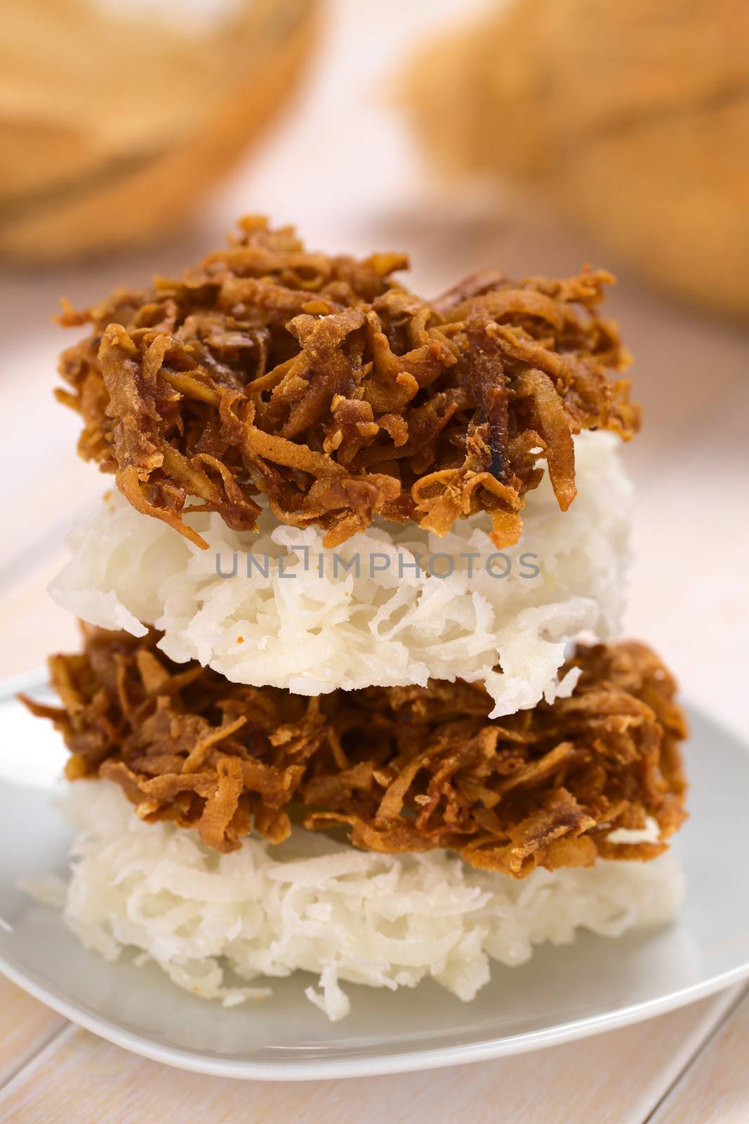 Peruvian cocadas, a traditional coconut dessert sold usually on the streets, made of grated coconut and white or brown sugar, which gives the different coloring of the sweet (Selective Focus, Focus on the front of the two upper cocadas)